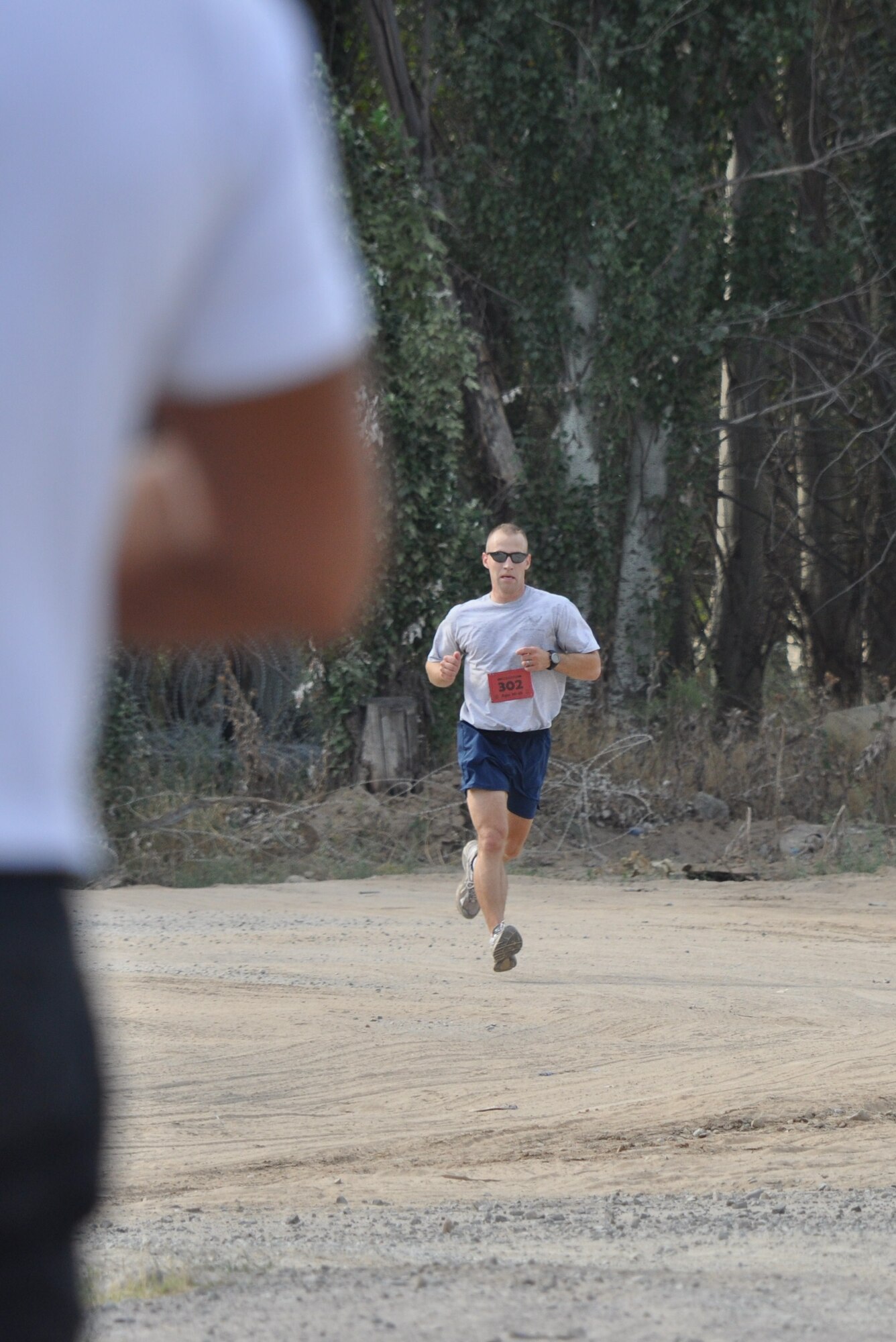 Capt. Ross Dotzlaf runs toward the finish line during a half-marathon race at the Transit Center at Manas, Kyrgyzstan, Aug. 8. Dotzlaf was the first runner to complete the race with a time of 1:24:45. He is deployed to the 376th Expeditionary Civil Engineer Squadron from Peterson Air Force Base, Colo. (U.S. Air Force photo/Senior Airman Chelsea Zalduondo)
