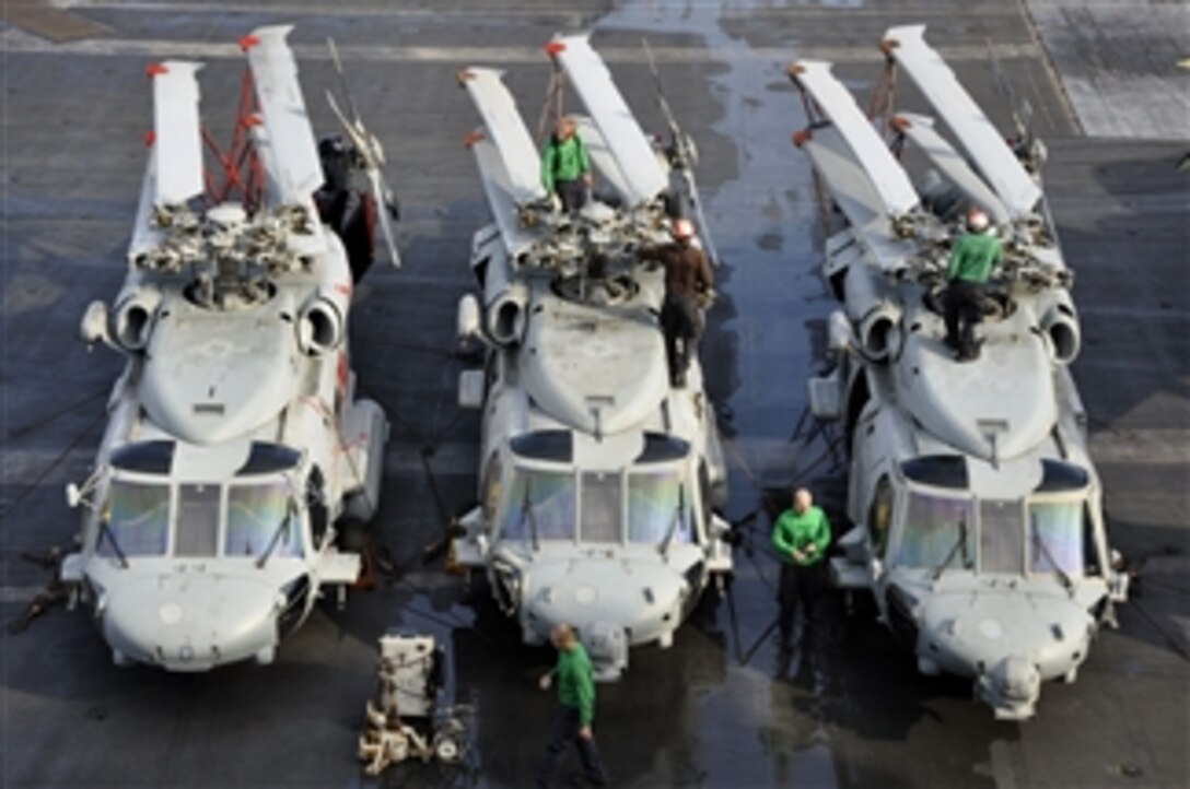 Sailors assigned to Helicopter Anti-Submarine Squadron 4 perform maintenance on MH-60S Sea Hawk helicopters aboard the aircraft carrier USS Ronald Reagan (CVN 76) in the South China Sea on Aug. 9, 2011.  The Ronald Reagan is underway in the U.S. 7th Fleet area of responsibility.  
