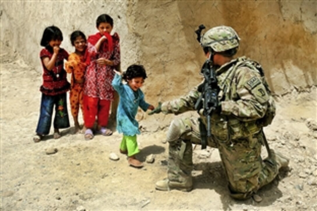 U.S. Air Force Senior Airman Sarah Baker greets children during a security halt in Qalat City, Afghanistan, Aug. 10, 2011. Baker is assigned to the Provincial Reconstruction Team Zabul's security force and is deployed from Malmstrom Air Force Base, Montana.