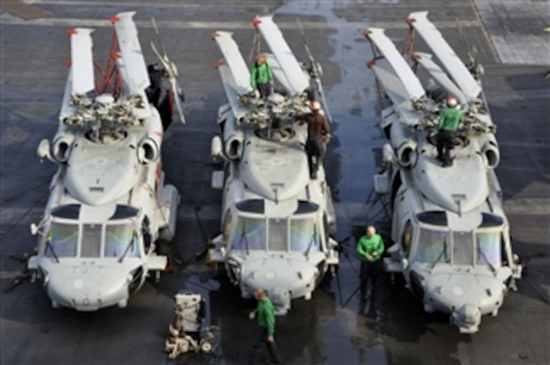 Sailors assigned to Helicopter Anti-Submarine Squadron 4 perform maintenance on MH-60S Sea Hawk helicopters aboard the aircraft carrier USS Ronald Reagan (CVN 76) in the South China Sea on Aug. 9, 2011.  The Ronald Reagan is underway in the U.S. 7th Fleet area of responsibility.  
