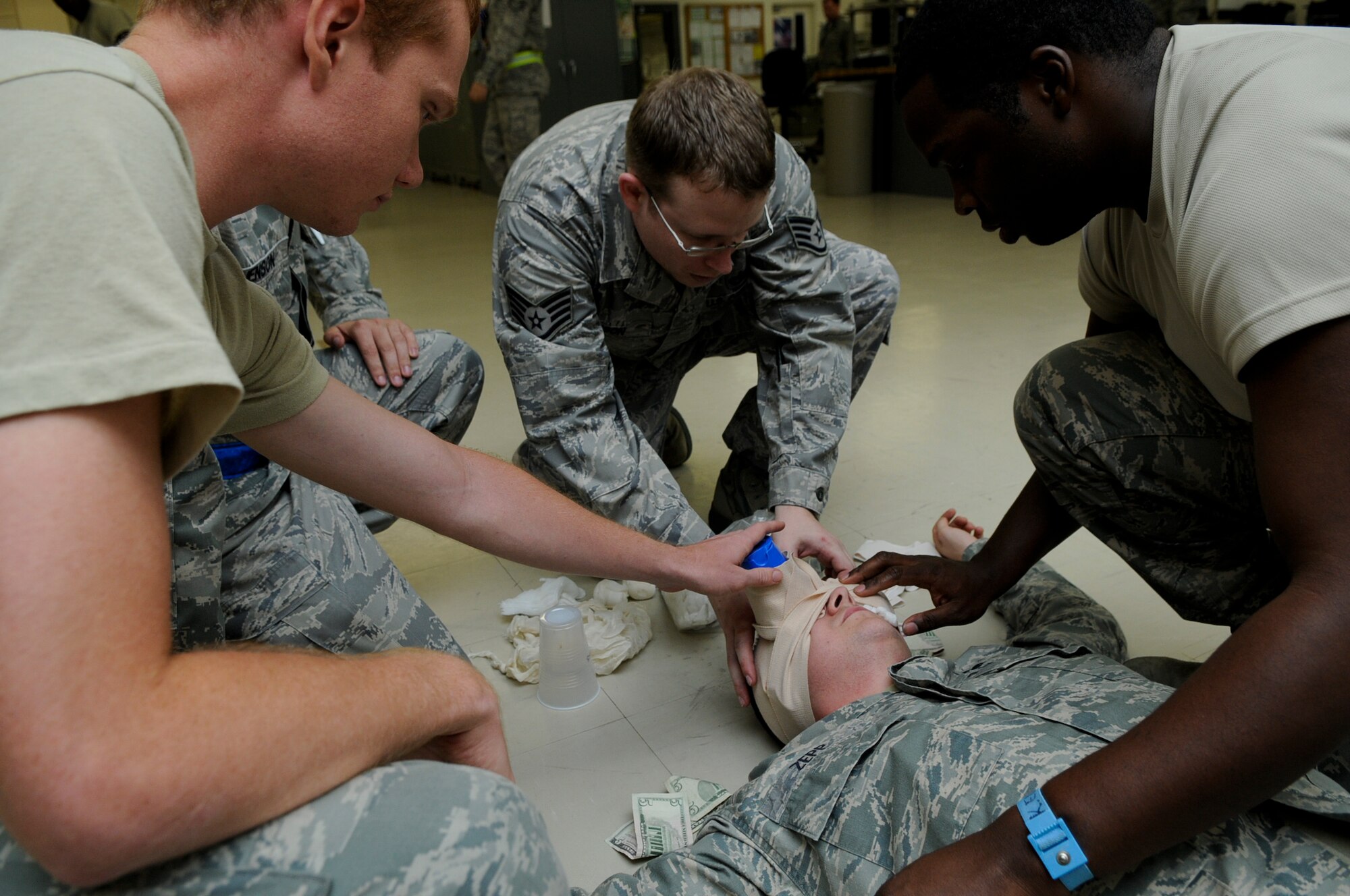 Members from the 18th Component Maintenance Squadron’s avionics shop respond to treat a simulated casualty following a simulated explosion in the shop Aug. 12. The simulation was part of Beverly High 11-6, a Local Operational Readiness Exercise, which tested Airmen in a multitude of emergent scenarios. (U.S. Air Force photo/Airman 1st Class Maeson L. Elleman)