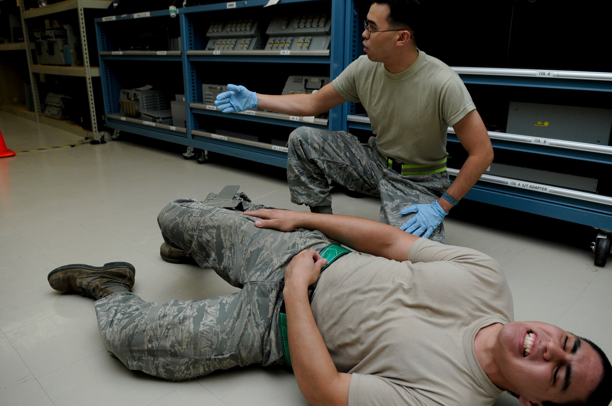 Senior Airman Thomas Stafford calls for help with Senior Airman Esteban Salmon, a simulated victim, following a simulated explosion in the 18th Component Maintenance Squadron’s avionics shop on Kadena Air Base, Japan, Aug. 12. The simulated explosion was part of Beverly High 11-6, a Local Operational Readiness Exercise, which tested Airmen’s responses to sudden simulated emergencies. (U.S. Air Force photo/Airman 1st Class Maeson L. Elleman)