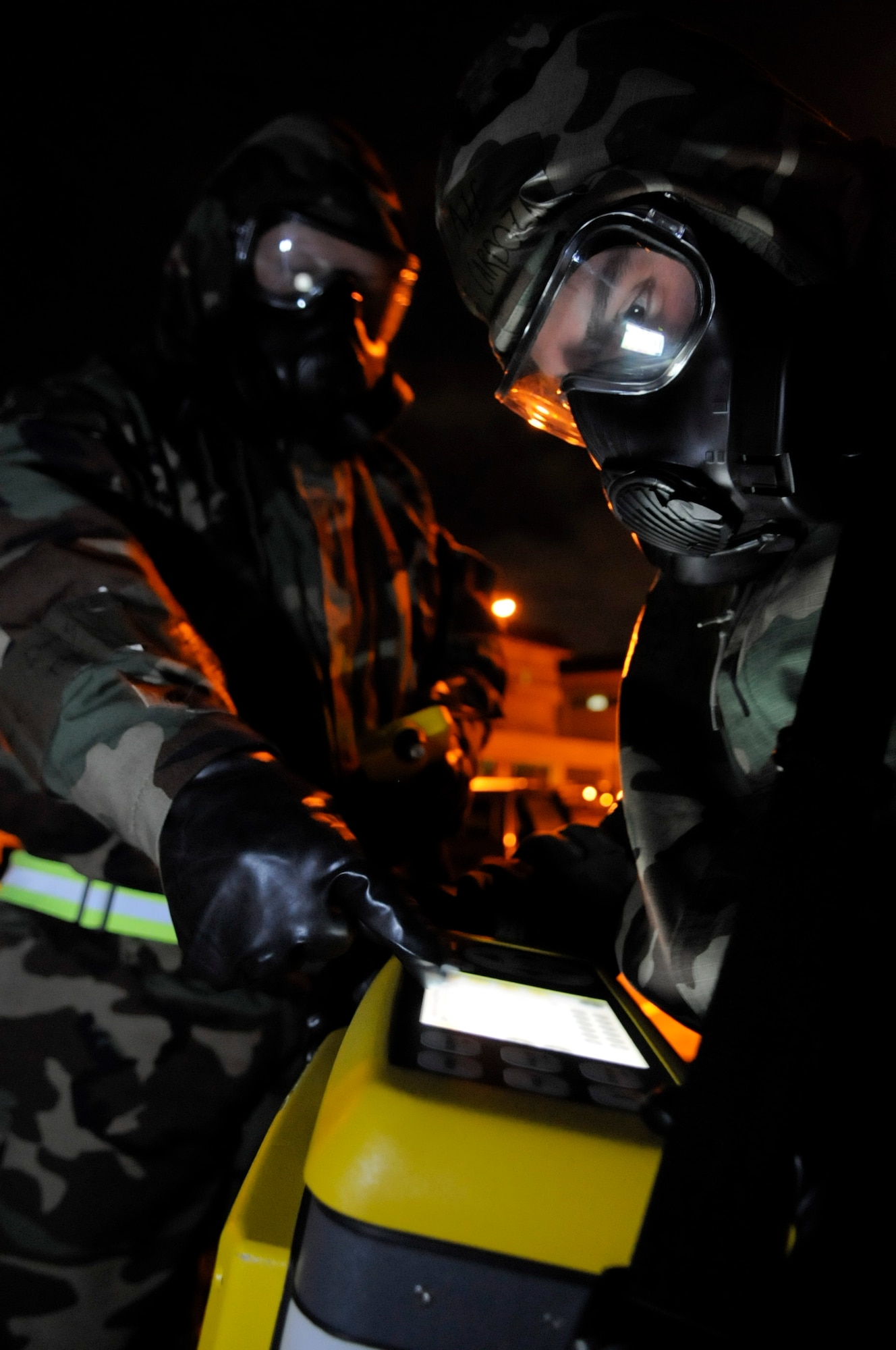 Staff Sgt. Brandon Kamai (left) indicates an environmental contamination reading to Senior Airman Jose Cardoza during Beverly High 11-6, a Local Operational Readiness Exercise on Kadena Air Base, Japan, Aug. 11. The LORE tested Airmen on their responses to a multitude of scenarios including explosions and environmental contamination. Cardoza and Kamai are both Bioenvironmental Engineering technicians from the 18th Aerospace Medicine Squadron. (U.S. Air Force photo/Airman 1st Class Maeson L. Elleman)