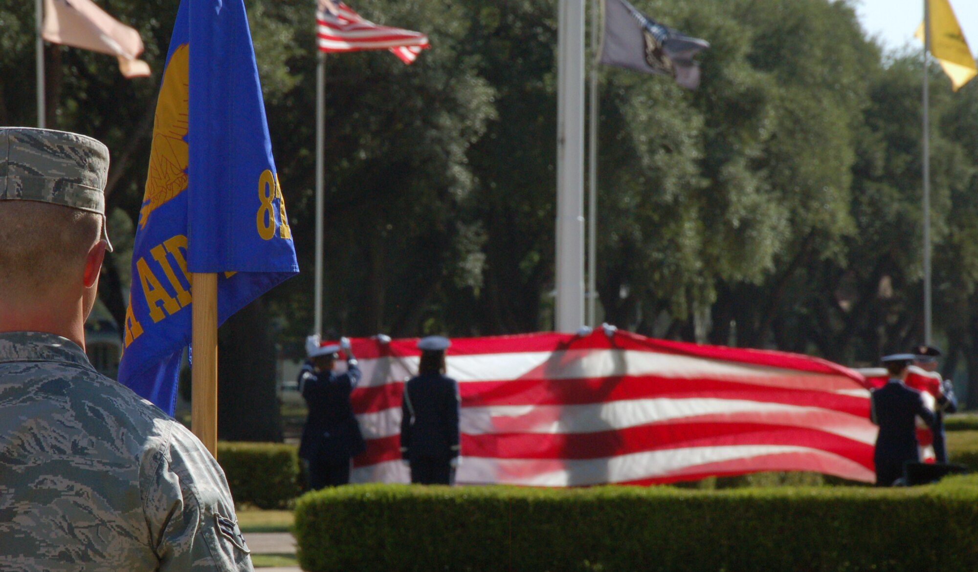 BARKSDALE AIR FORCE BASE, La. – Airman 1st Class Joshua Freedman, 608th Air and Space Operations Center, stands at attention as members of the 2nd Bomb Wing Base Honor Guard prepare to fold the U.S. flag during a retreat ceremony Aug.10, 2011, at Barksdale Air Force Base, La. The Eighth Air Force Headquarters and 2nd Medical Group performed the retreat ceremony, which serves a twofold purpose. It signals the end of the official duty day and serves as a ceremony for paying respect to the flag. When persons not assigned to a formation are outdoors and in uniform, on the first note of retreat, they should face the flag (if visible) or music and assume the position of parade rest. (U.S. Air Force photo by Staff Sgt. Brian Stives)