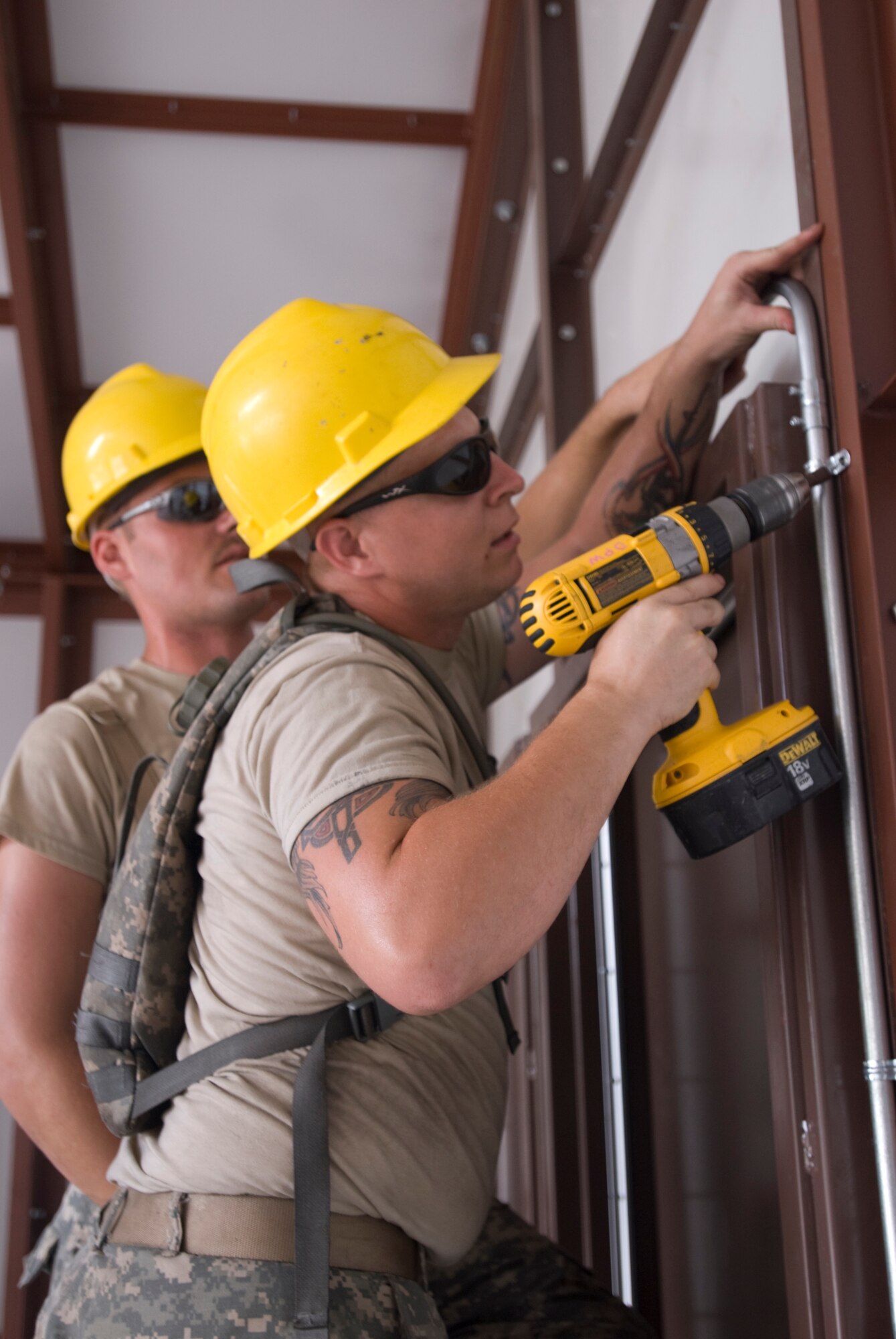 Private first class David R. Sauceman, engineer for 1st Platoon of the 733rd Engineer Company, fastens an anchor for electrical wiring in the 50-person classroom during Castle Installation Related Construction July 25 at Joint Base McGuire-Dix-Lakehurst. (U.S. Army photo by Spc. Amber Hoy/Released)