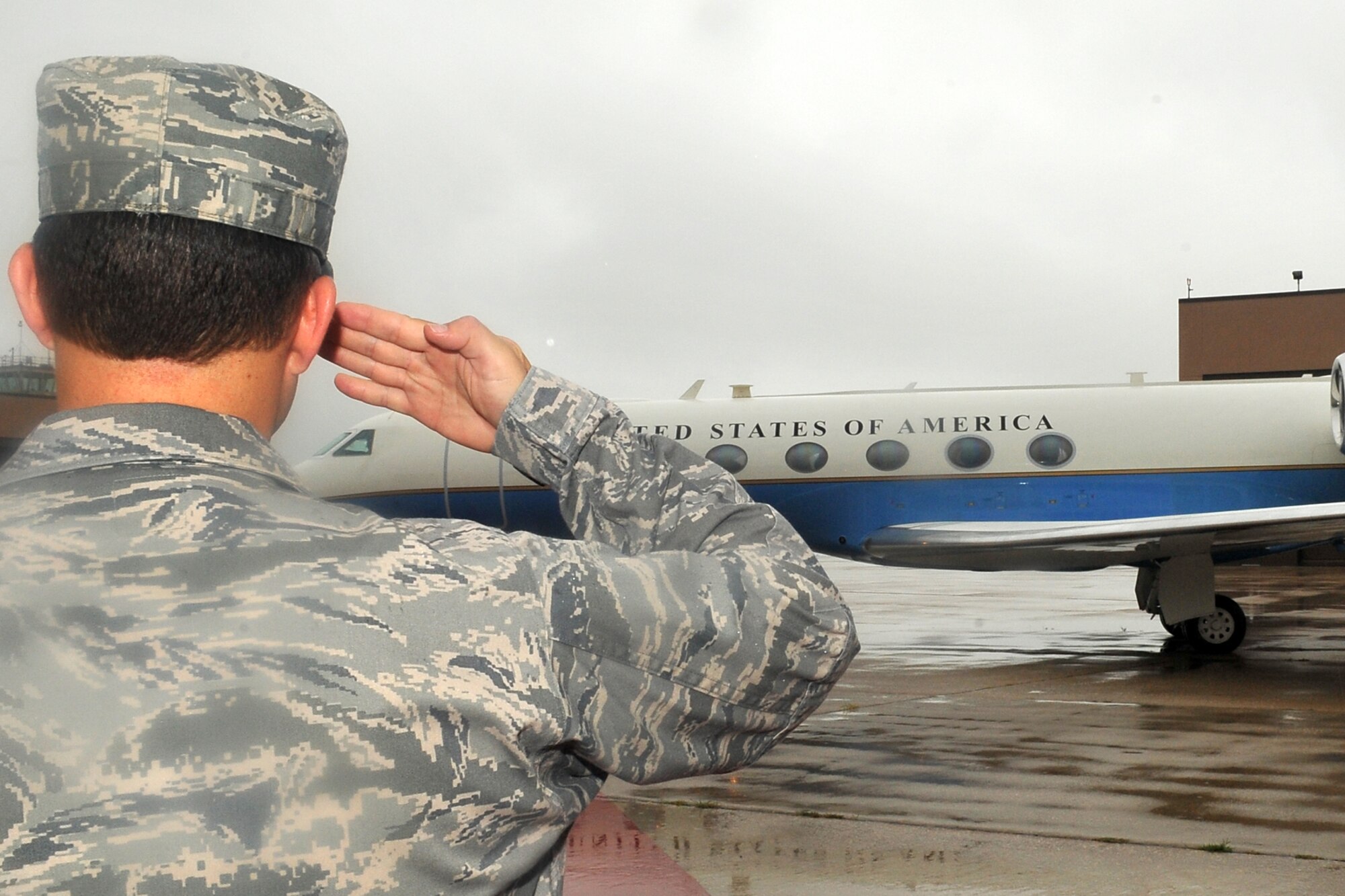 U.S. Air Force Brig. Gen. Donald Bacon, 55th Wing commander, salutes as the aircraft carrying Secretary of Defense Leon Panetta, prepares to park at the Base Operations building on Offutt Air Force Base, Neb., Aug. 5. Panetta came to offutt to visit U.S. Strategic Command leadership and Service members. (U.S. Air Force Photo by Charles Haymond)