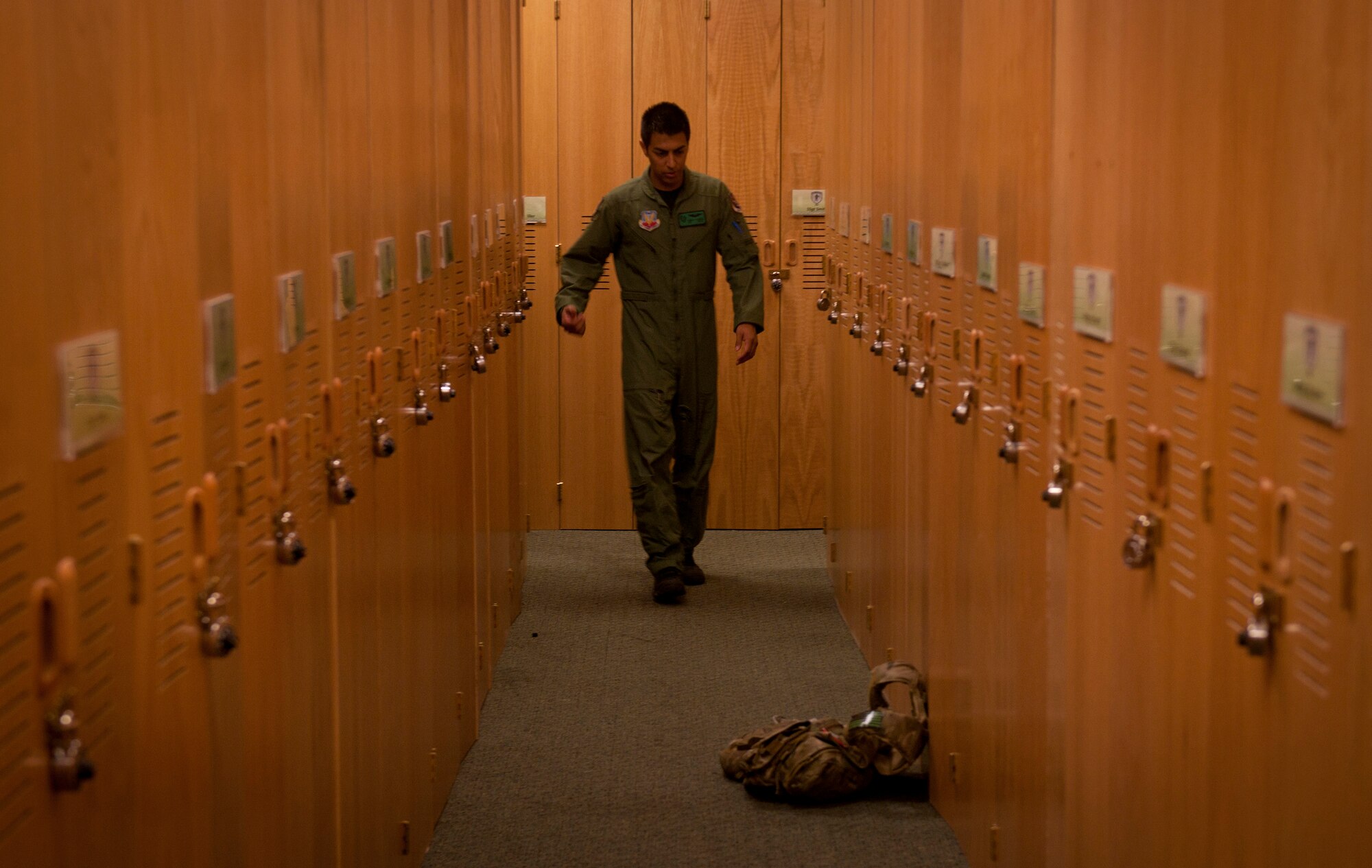 U.S. Air Force Airman 1st Class Henry Flores, 41st Rescue Squadron aerial gunner, walks down an aisle of lockers to pick up his eagles vest before departing for a flight at Moody Air Force Base, Ga., Aug. 3, 2011. HH-60 aerial gunners go through four different courses including aircrew fundamentals and survival, evasion, resistance and escape training. (U.S. Air Force photo by Airman 1st Class Joshua Green/Released)

