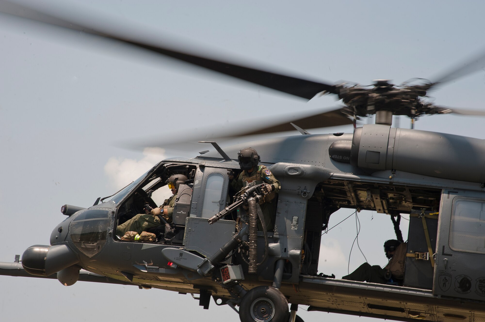 U.S. Air Force Airman 1st Class Henry Flores, 41st Rescue Squadron aerial gunner, stays alert while members of his crew prepare to drop a rope ladder during a training mission at Grand Bay Bombing and Gunnery Range, Ga., Aug. 3, 2011. While at home, aerial gunners fly two to three times a week to maintain their qualifications and fine tune their skills. (U.S. Air Force photo by Airman 1st Class Jarrod Grammel/Released)
