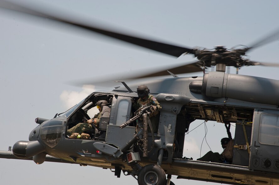 U.S. Air Force Airman 1st Class Henry Flores, 41st Rescue Squadron aerial gunner, stays alert while members of his crew prepare to drop a rope ladder during a training mission at Grand Bay Bombing and Gunnery Range, Ga., Aug. 3, 2011. While at home, aerial gunners fly two to three times a week to maintain their qualifications and fine tune their skills. (U.S. Air Force photo by Airman 1st Class Jarrod Grammel/Released)
