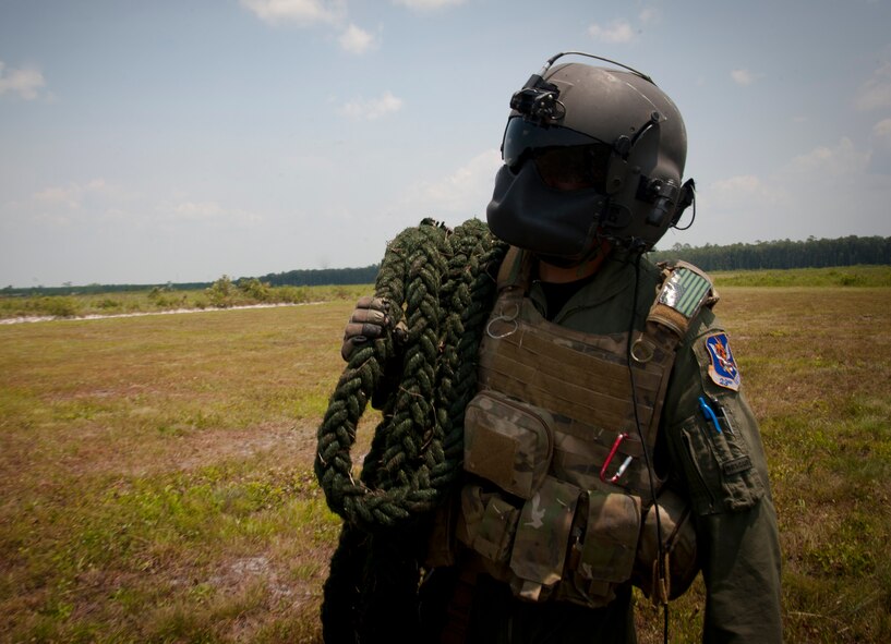 U.S. Air Force Airman 1st Class Henry Flores, 41st Rescue Squadron aerial gunner, retrieves a fast rope that was dropped from the HH-60G Pave Hawk during a training mission at Grand Bay Bombing and Gunnery Range, Ga., Aug. 3, 2011. As part of an aircrew on HH-60s, aerial gunners have to be efficient at employing alternate insertion and extraction methods to bring friendly forces to safety. (U.S. Air Force photo by Airman 1st Class Jarrod Grammel/Released)
