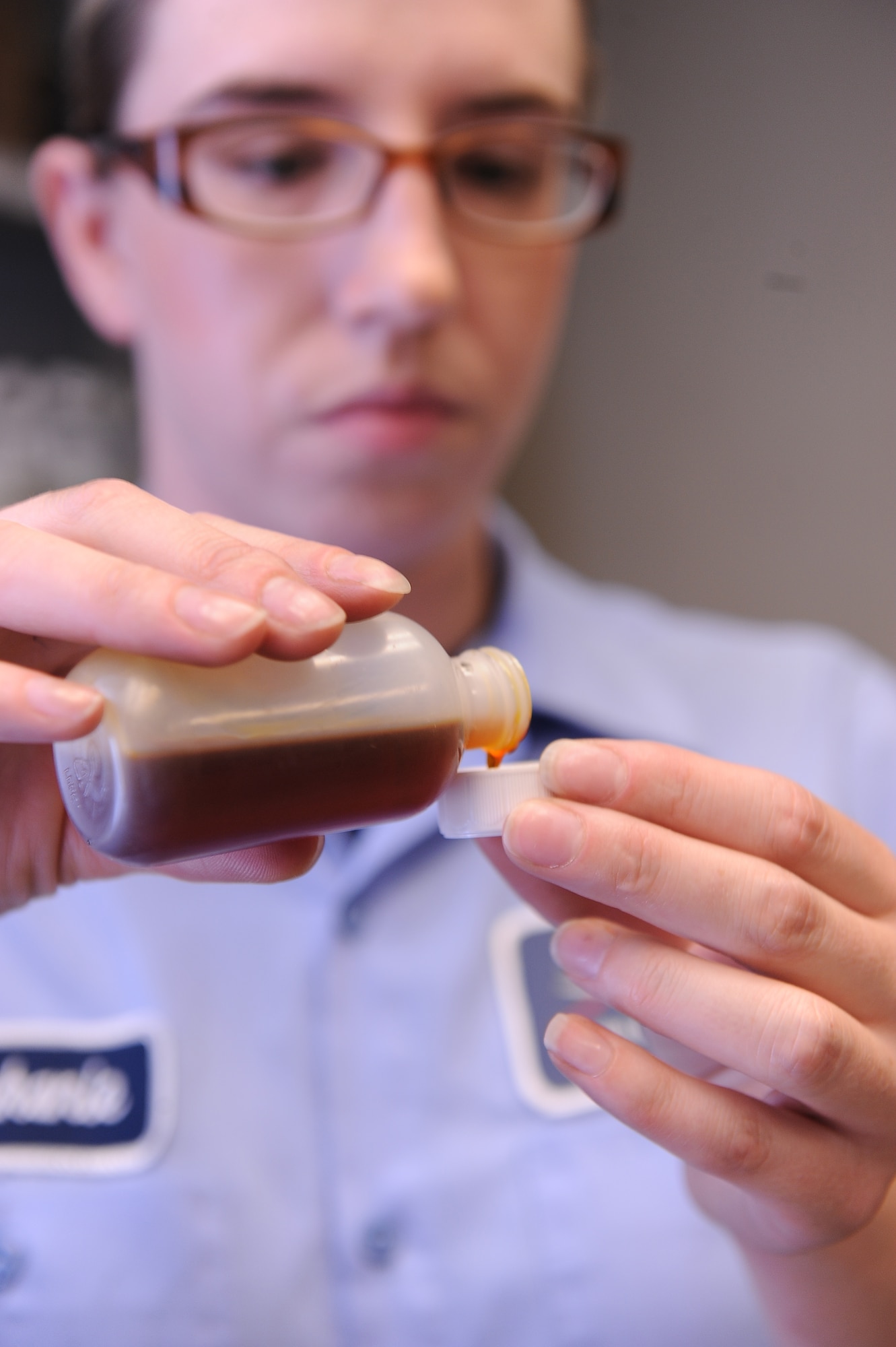 Stephanie Zvonik, Computer Science Corporation aircraft mechanic 1 nondestructive inspection technician, pours a sample of aircraft engine oil to perform a joint oil analysis, Aug. 1, 2011, at Nellis Air Force Base, Nev.  The analysis of aircraft oils can detect wear of individual parts. Without it, major components can fail going undetected. Zvonik tests up to 80 samples a day. (U.S Air Force photo by Senior Airman Stephanie Rubi/Released) 