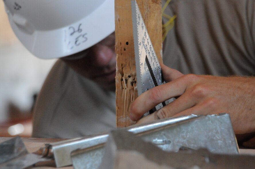 Staff Sgt. Caleb Craft, structural team leader, lines up flooring beams during a project to lower a raised floor by 1.75 inches. The 126th Civil Engineering Squadron, Illiinois Air National Guard, is assisting the California Army National Guard in renovations at Camp Roberts, Cali. The Army National Guard training base was created in 1941 to support troops leaving for World War II and is now in need of repairs to buildings and infrastructure. Air National Guard Civil Engineering squadrons are using the opportunity to train on real world electrical, structural, plumbing and heavy equipment scenarios. This creates a  collaboration that proves valuable to both National Guard components. (U.S. Air Force photo by Master Sgt. Ken Stephens)