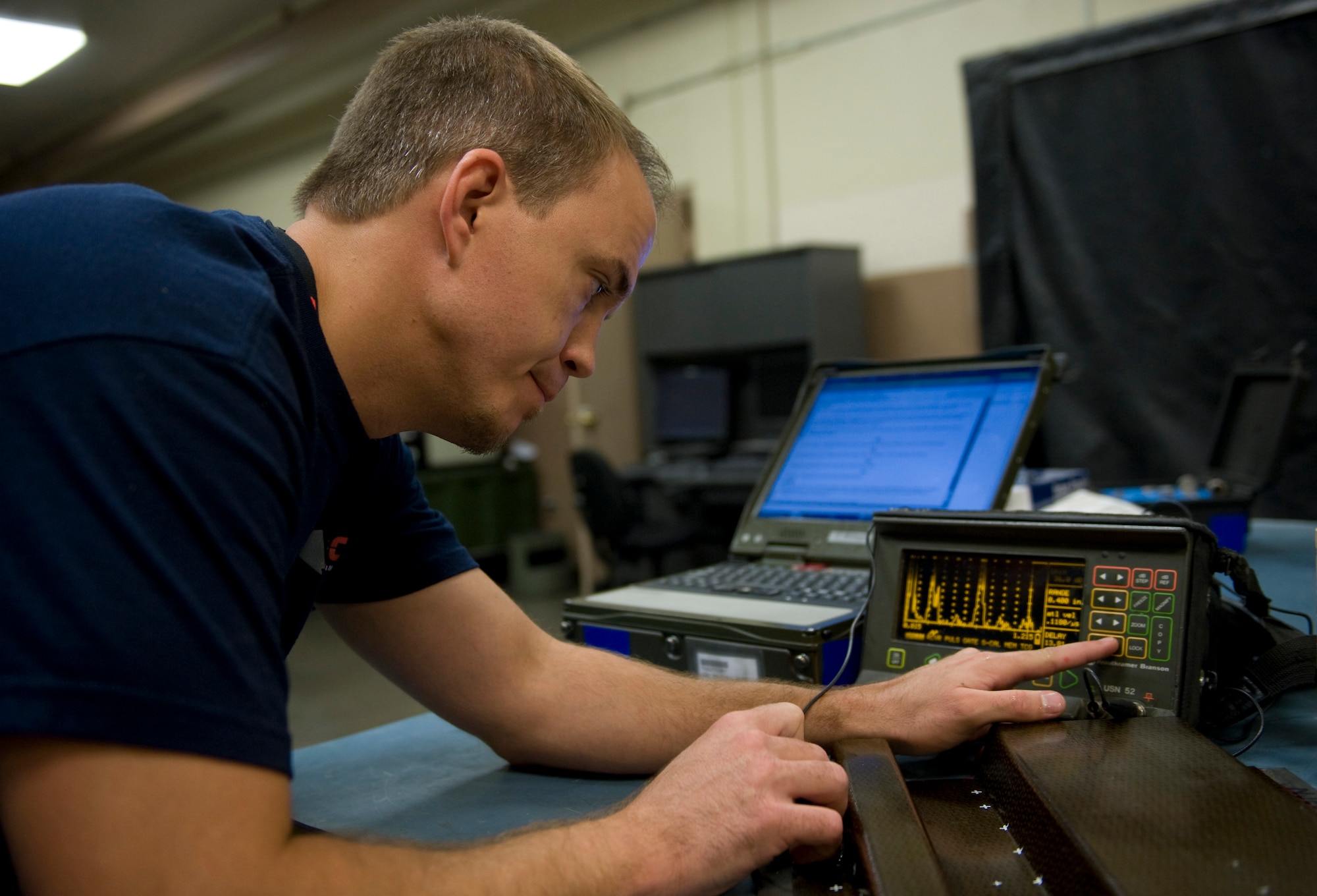 Joey Mabrey, Computer Science Corporation aircraft mechanic 2 nondestructive inspection technician calibrates an ultrasonic machine Aug. 5, 2011, at Nellis Air Force Base, Nev.  Mabrey uses the information received during the calibration to perform inspections on Nellis AFB aircrafts.  (U.S Air Force photo by Senior Airman Stephanie Rubi/Released)