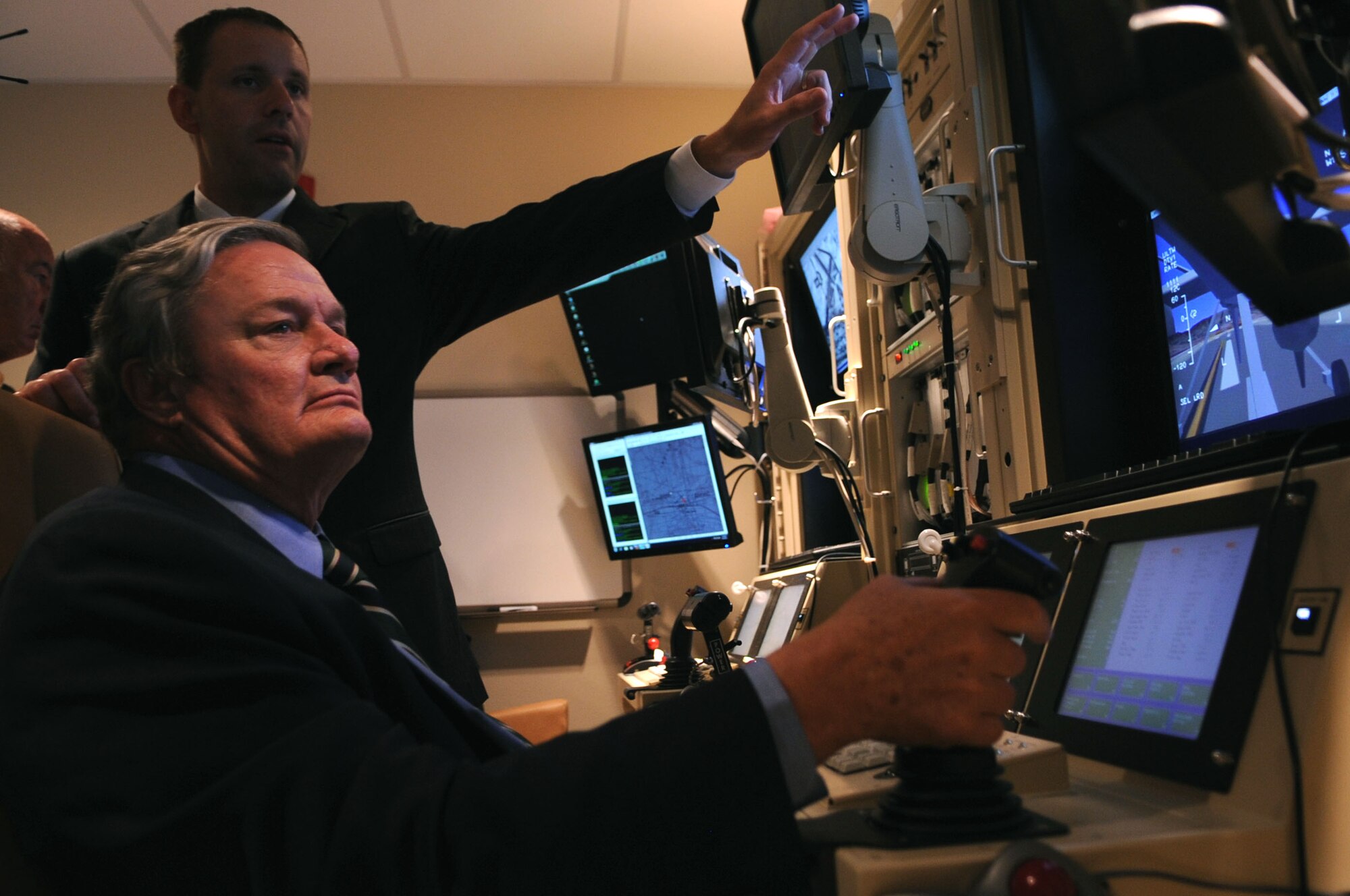 The governor of North Dakota, Jack Dalrymple, attempts to maneuver an Unmanned Aircraft System during the dedication of the University of North Dakota UAS Training Facility on Grand Forks Air Force Base Aug 10. The UND Unmanned Aircraft Systems Center of Excellence was established in 2006 and focuses on education and training for UAS integration into national airspace systems.  (U.S. Air Force photo by Senior Airman Amanda N. Stencil)
