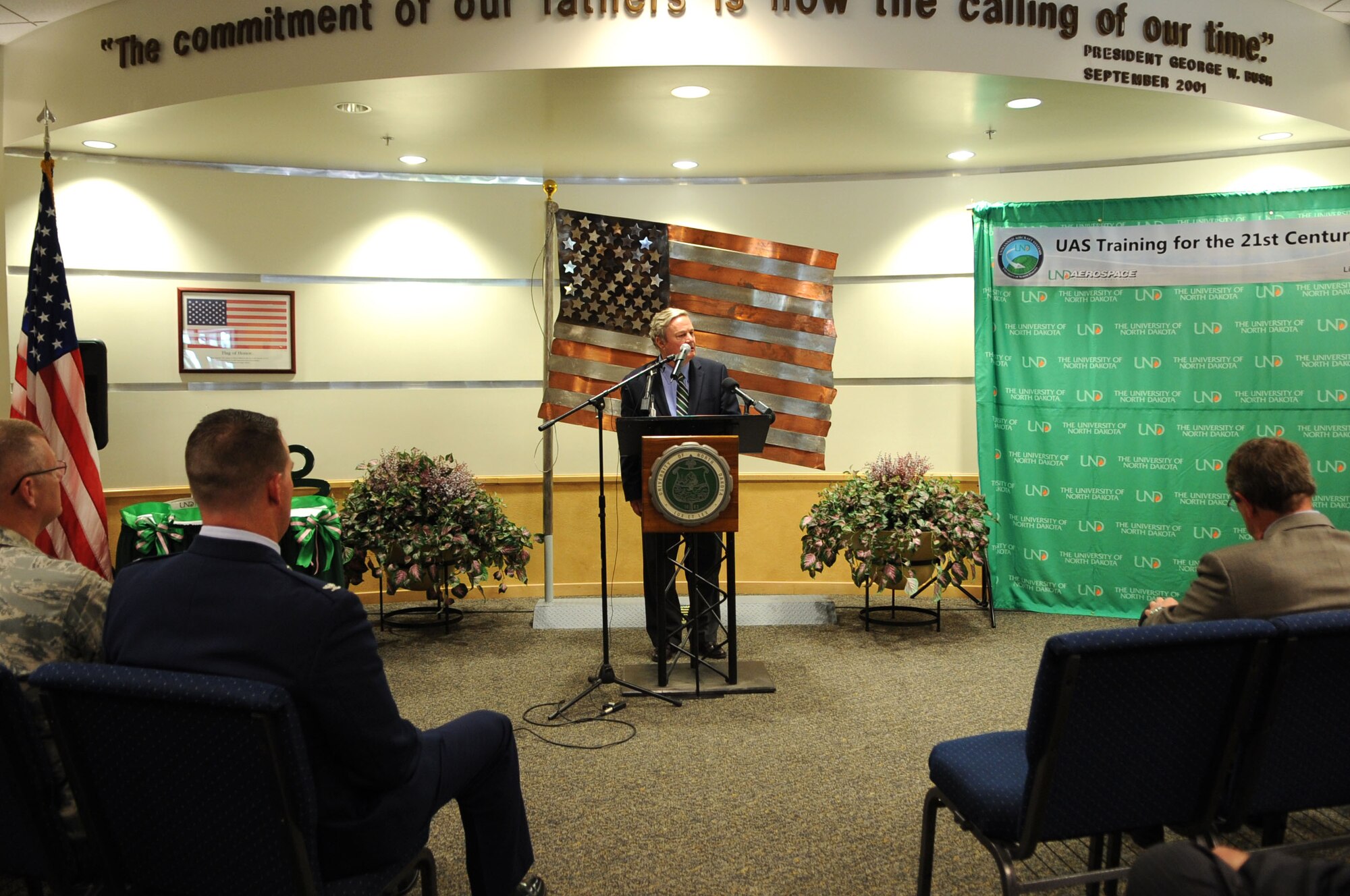 The governor of North Dakota, Jack Dalrymple, speaks to an audience about the dedication of the University of North Dakota Unmanned Aircraft Systems Training Facility opening up on Grand Forks Air Force Base on Aug 10. The UND Unmanned Aircraft Systems Center of Excellence was established in 2006 and focuses on education and training for UAS integration into national airspace systems. . (U.S. Air Force photo by Senior Airman Amanda N. Stencil)