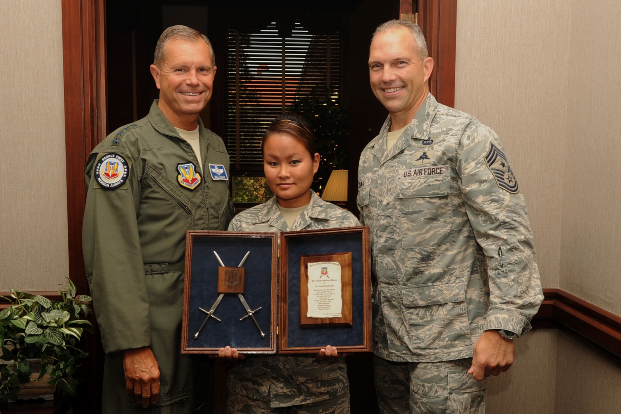 Gen. William M. Fraser III, Air Combat Command commander, is presented an invitation to The Order of the Sword ceremony by Senior Airman Iris Cruz, Air Combat Command Defense Security Assistance Agency knowledge operations management journeyman, and Chief Master Sgt. Martin Klukas, ACC command chief, at Langley Air Force Base, Va., Aug. 11, 2011. The Order of the Sword is the highest honor Air Force enlisted members can present to senior officers. (U.S. Air Force photo by Airman 1st Class Racheal Watson/Released)