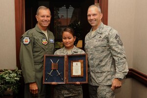 Gen. William M. Fraser III, Air Combat Command commander, is presented an invitation to The Order of the Sword ceremony by Senior Airman Iris Cruz, Air Combat Command Defense Security Assistance Agency knowledge operations management journeyman, and Chief Master Sgt. Martin Klukas, ACC command chief, at Langley Air Force Base, Va., Aug. 11, 2011. The Order of the Sword is the highest honor Air Force enlisted members can present to senior officers. (U.S. Air Force photo by Airman 1st Class Racheal Watson/Released)