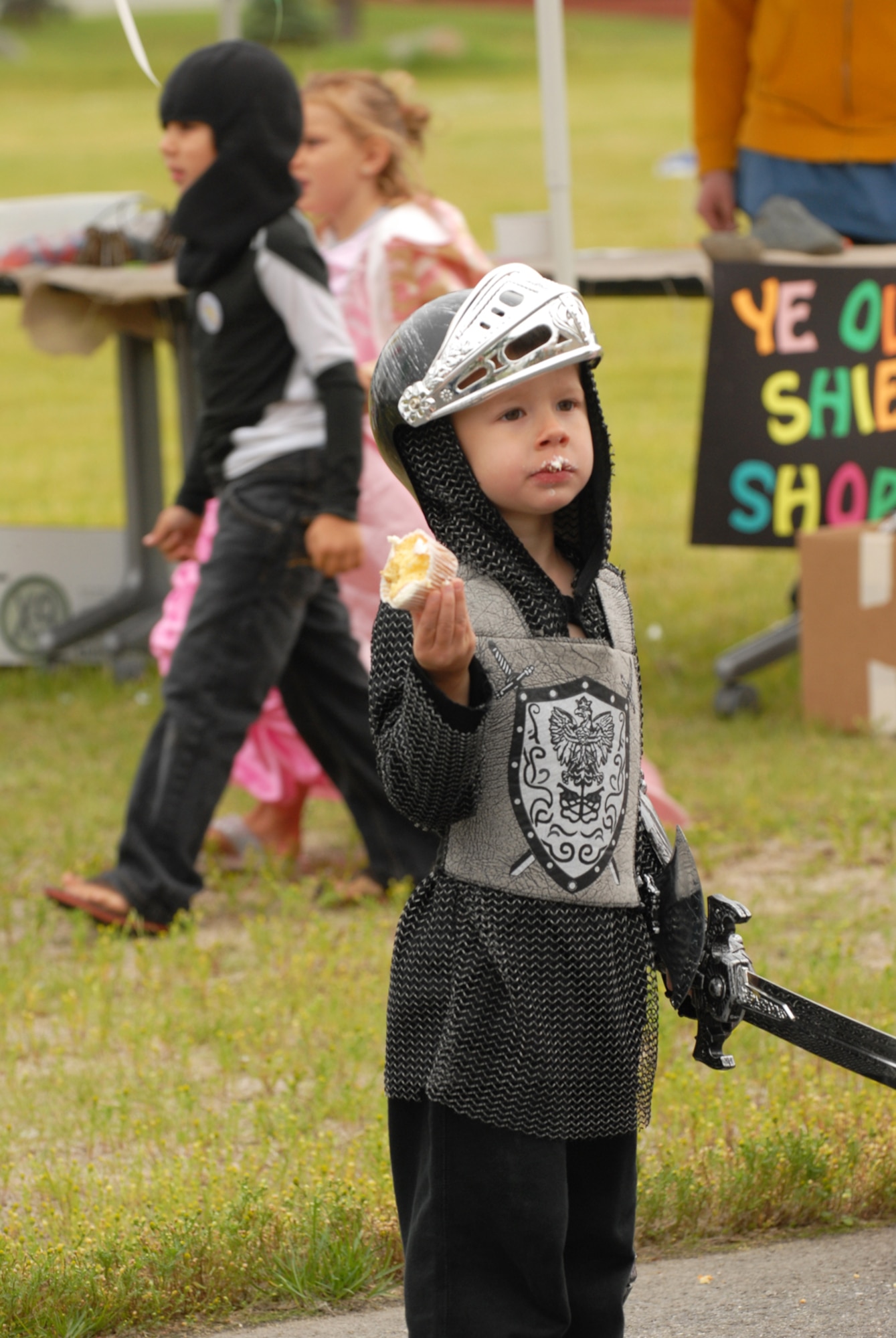 Black Knight Marek Pecina enjoys a snack. Children of the Joint Base Elmendorf-Richardson attended the "A Midsummer Knights Read" on the grounds of the base library. Activites included shield decorating, hat making and marshmallow catapult contest. Members of the local Society for Creative Anachronism were on hand with members dressed in the period and sword fighting in armour was displayed. (U.S. Air Force photo/Steven White)