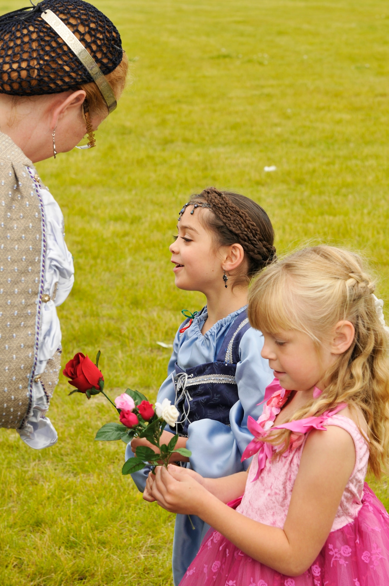 Princess Lacie Wright andPrincess  Hailey Newberry receive hamade flowers during the  Joint Base Elmendorf-Richardson event "A Midsummer Knights Read" on the grounds of the base library. Activites included shield decorating, hat making and marshmello catapult contest. Members of the local Society for Creative Anachronism were on hand with members dressed in the period and sword fighting in armour was displayed. (U.S. Air Force photo/Steven White)