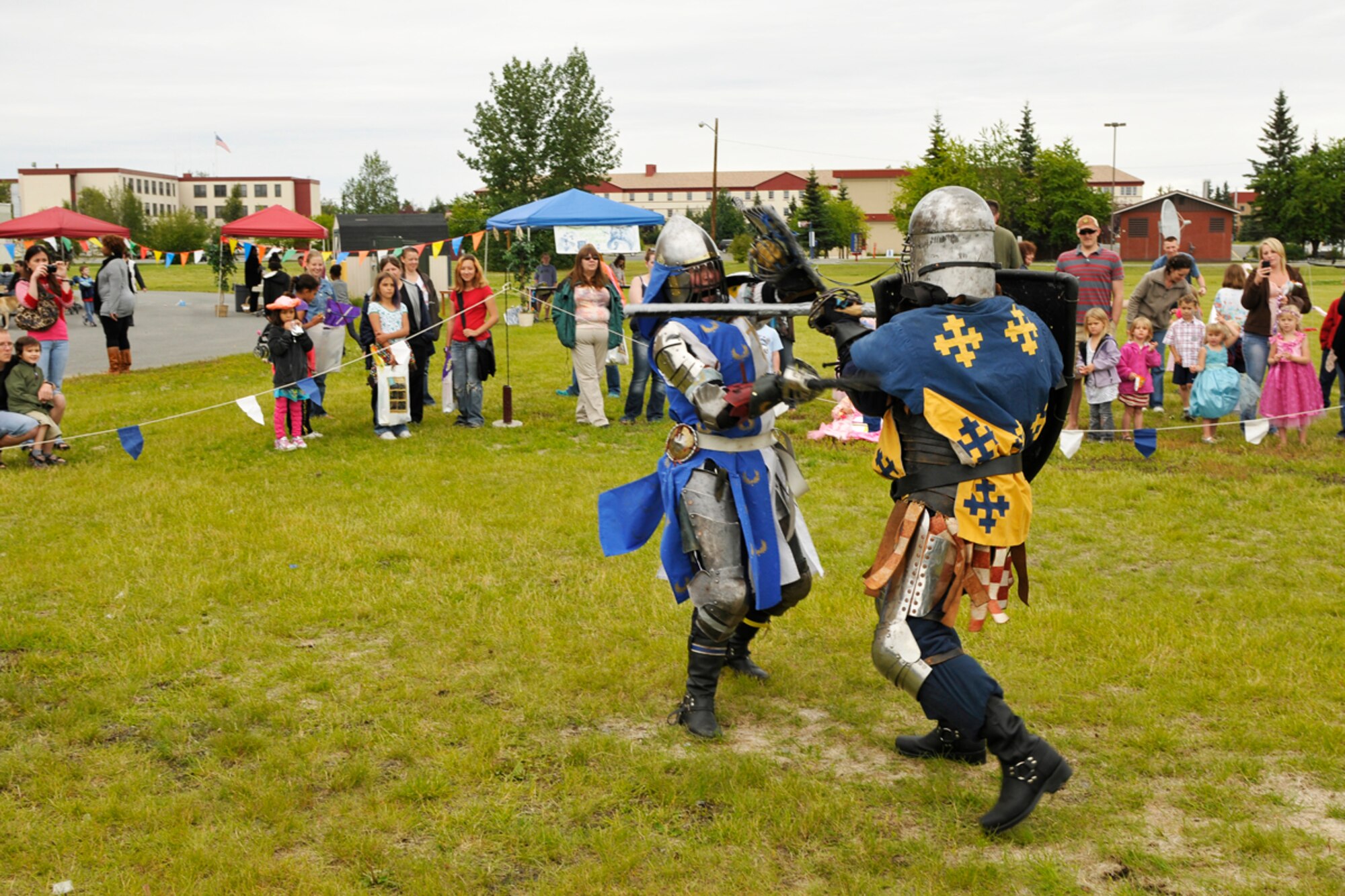 Knights of the Barony of Eskolya, Anchorage, duel in front of an audiance  during the  Joint Base Elmendorf-Richardson event "A Midsummer Knights Read" on the grounds of the base library. Activites included shield decorating, hat making and marshmallow catapult contest. Members of the local Society for Creative Anachronism were on hand with members dressed in the period and sword fighting in armour was displayed. (U.S. Air Force photo/Steven White)
