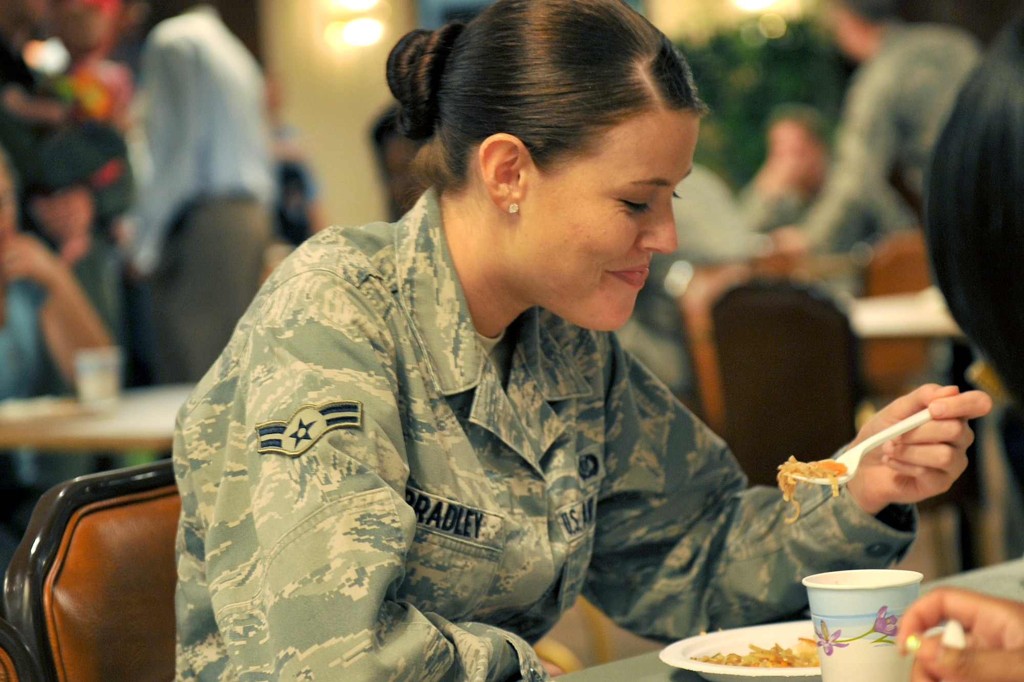 Air Force Airman 1st Class Jessica Bradley, from the 338th Combat Training Squadron prepares to take a bite from her plate during the 2011 Diversity Day events at the Community Center on Aug. 5, 2011, at Offutt Air Force Base, Neb.  Diversity Day was held at the community center and offered attendees an array of dishes from around the world. (U.S. Air Force photo by Jeff W. Gates)