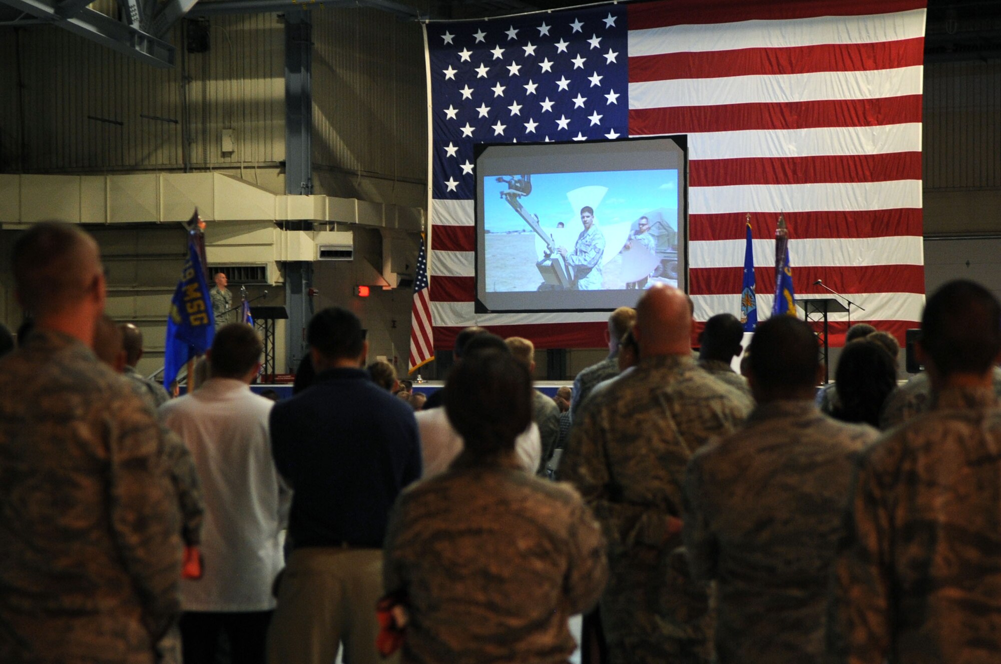 Members of Grand Forks Air Force Base watch a video about the Air Mobility Command before receiving results to a Compliance Inspection on GFAFB Aug 9. A CI is an inspection conducted to assess areas mandated by law, as well as mission areas identified by leadership as critical or important to the health and performance of a unit. The 319th Air Base WIng received an overall rating of "excellent". (U.S. Air Force photo by Senior Airman Amanda N. Stencil) 
