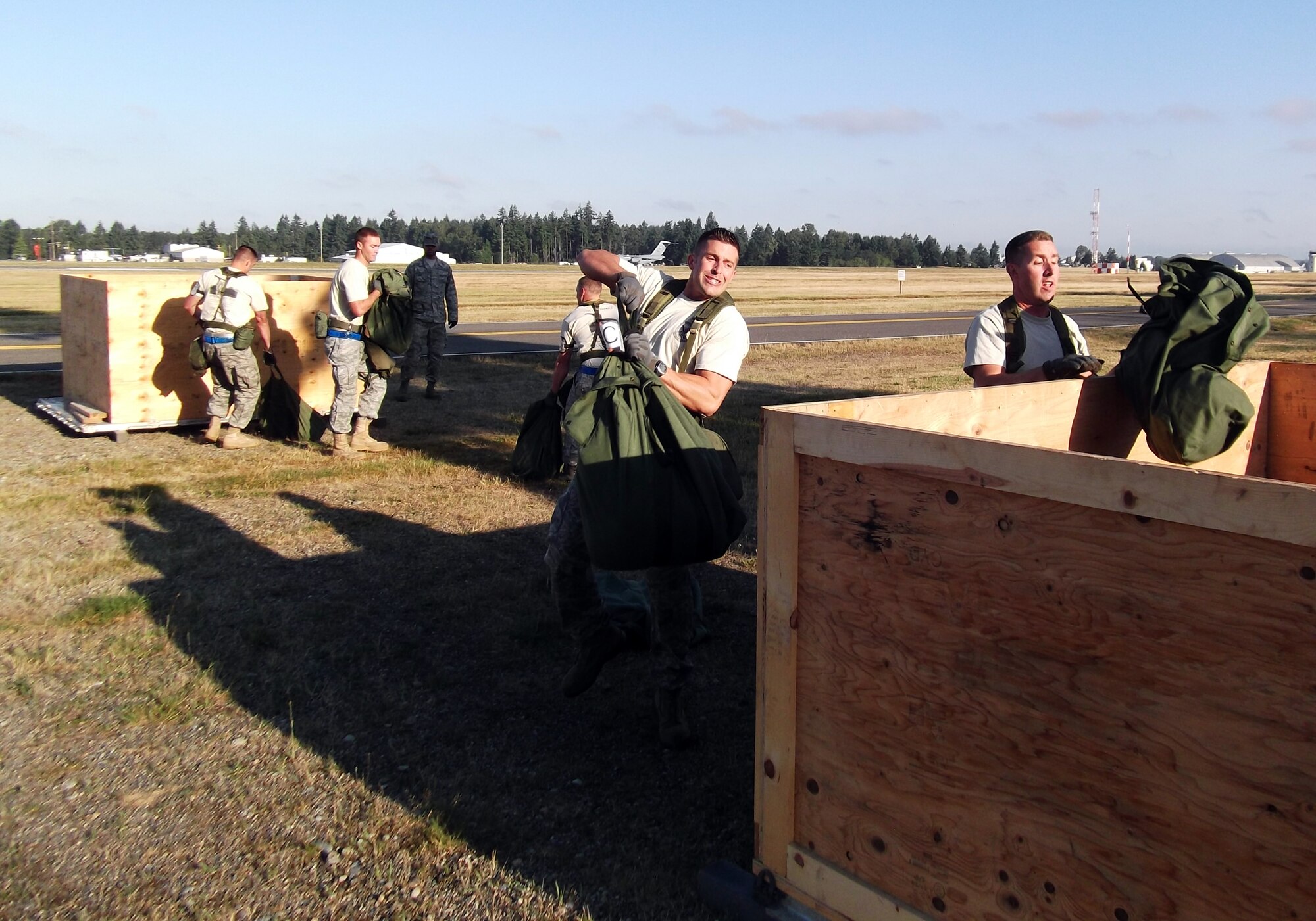 Senior Airman Sterling Broadhead (center), 67th Aerial Port Squadron, transfers weighted duffel bags from one crate to another during the recent Air Mobility Rodeo competition at Joint Base Lewis-McChord, Wash. (Courtesy photo)