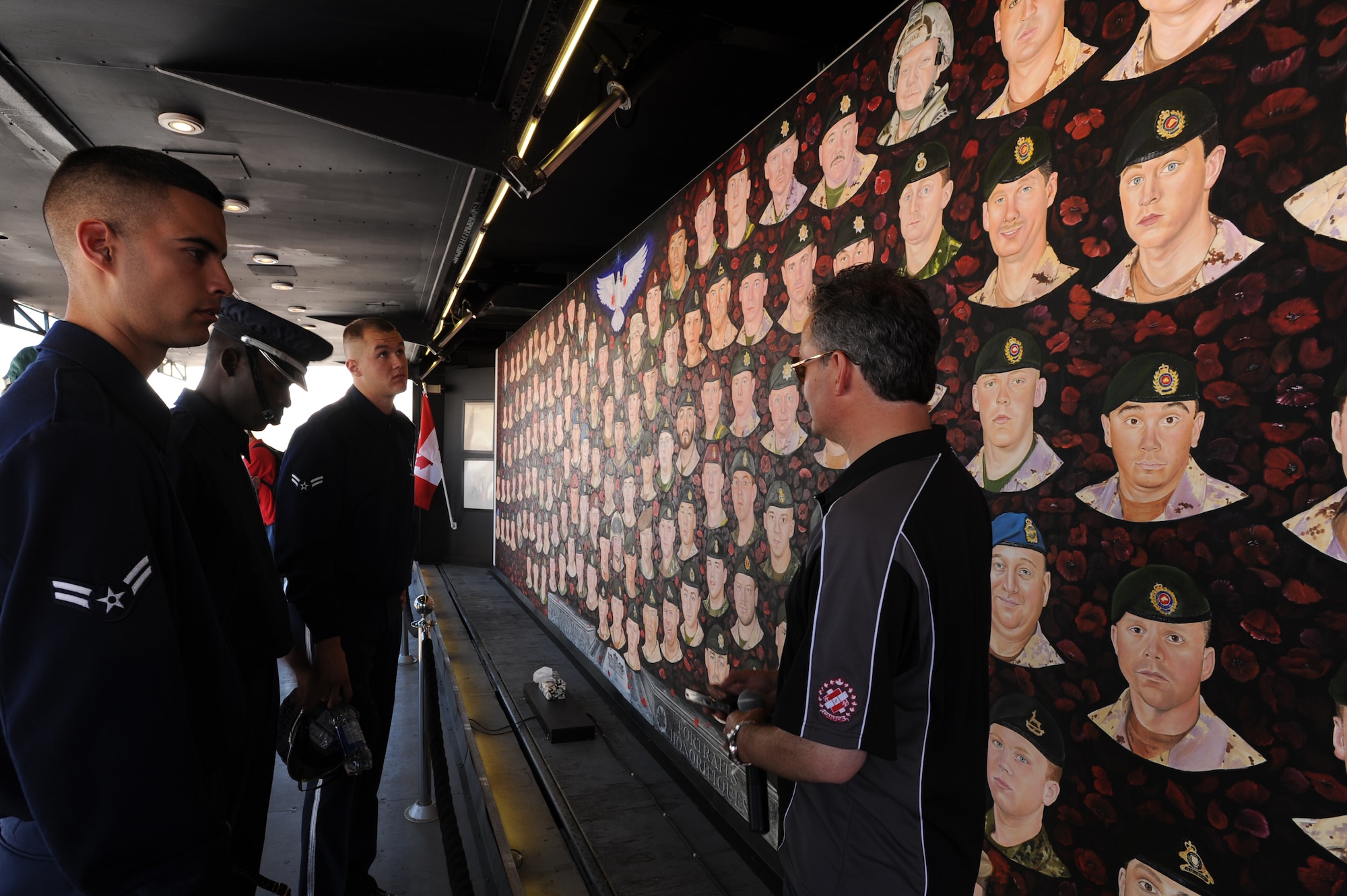 Members of the U.S. Air Force Honor Guard Drill Team are briefed about the Portraits of Honor in Saskatoon, Canada Aug. 6. The Portraits of Honor is being painted by Canadian artist Dave Sopha, and currently holds the faces of 155 Canadian Armed force’s members who have been killed in the war in Afghanistan. (U.S. Air Force photo by Staff Sgt. Christopher Ruano)
