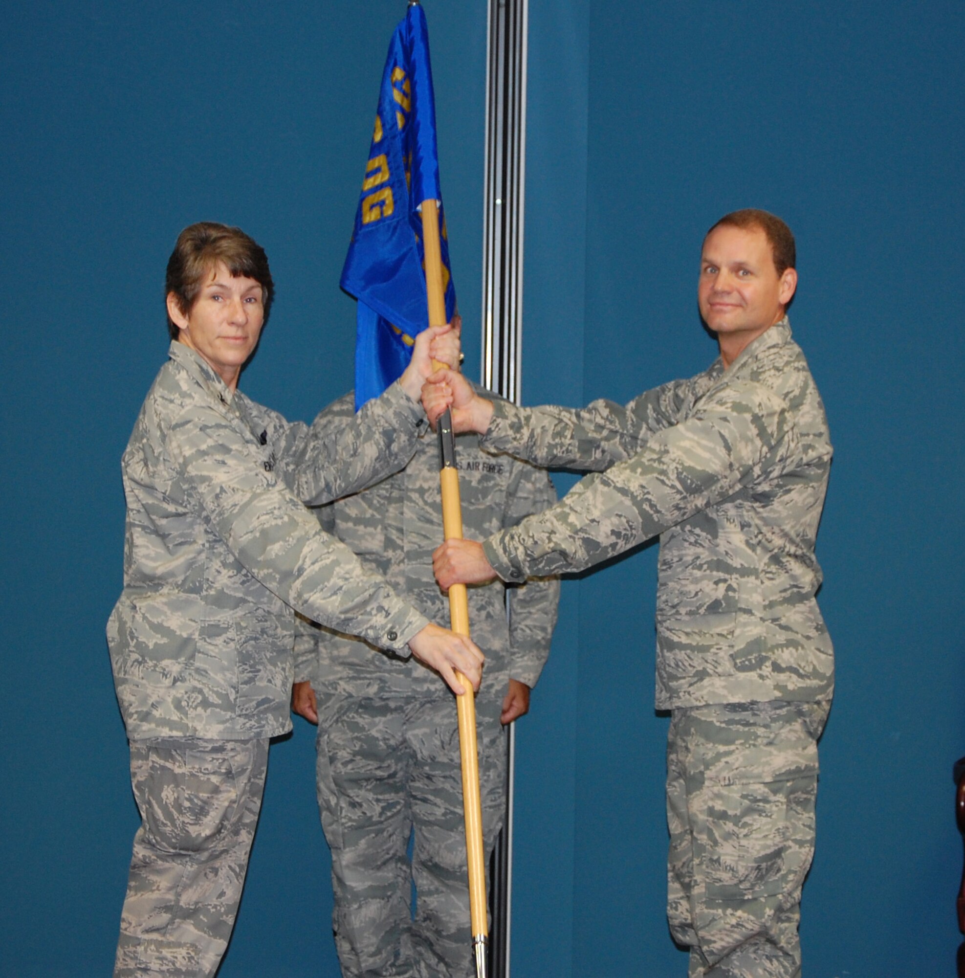 Col. Caroline Evernham (left), 916th Operations Group commander, passes the 916th Operations Support Squadron guidon to Lt. Col. Douglas Miller, the new squadron commander. Miller comes from Travis Air Force Base, Calif. (USAF photo by TSgt. Scotty Sweatt, 916ARW/PA)