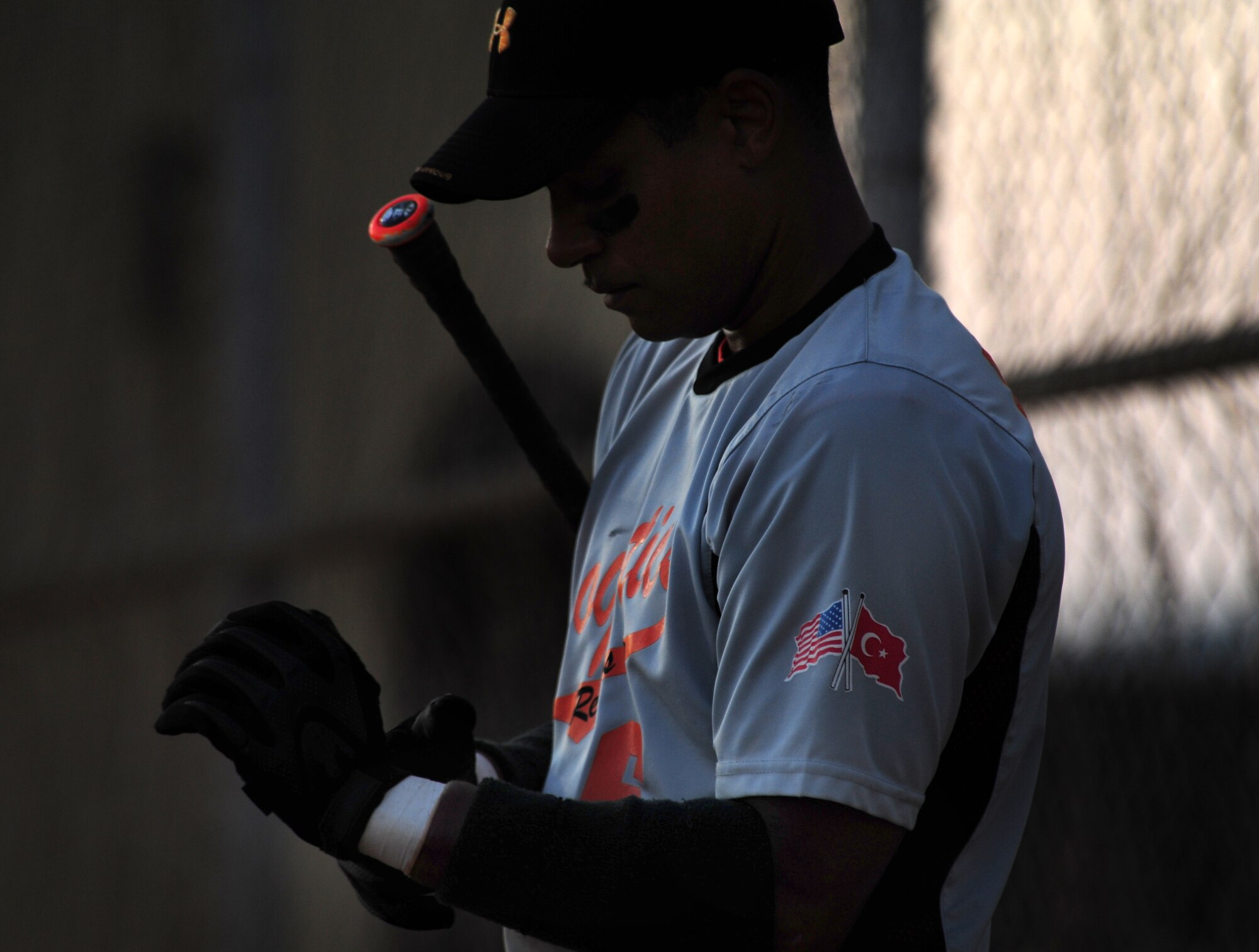 Darrell Wagner, 39th Logistics Readiness Squadron, puts on his gloves before going up to bat during an annual softball championship game Aug. 9, 2011, at Incirlik Air Base, Turkey. The 39th LRS played the 39th Security Forces Squadron in the base championship, which consisted of two games. The 39th LRS won the first game 11-8, and the 39th SFS won the title in the second game with a score of 13-2. (U.S. Air Force photo by Senior Airman Anthony Sanchelli/Released)