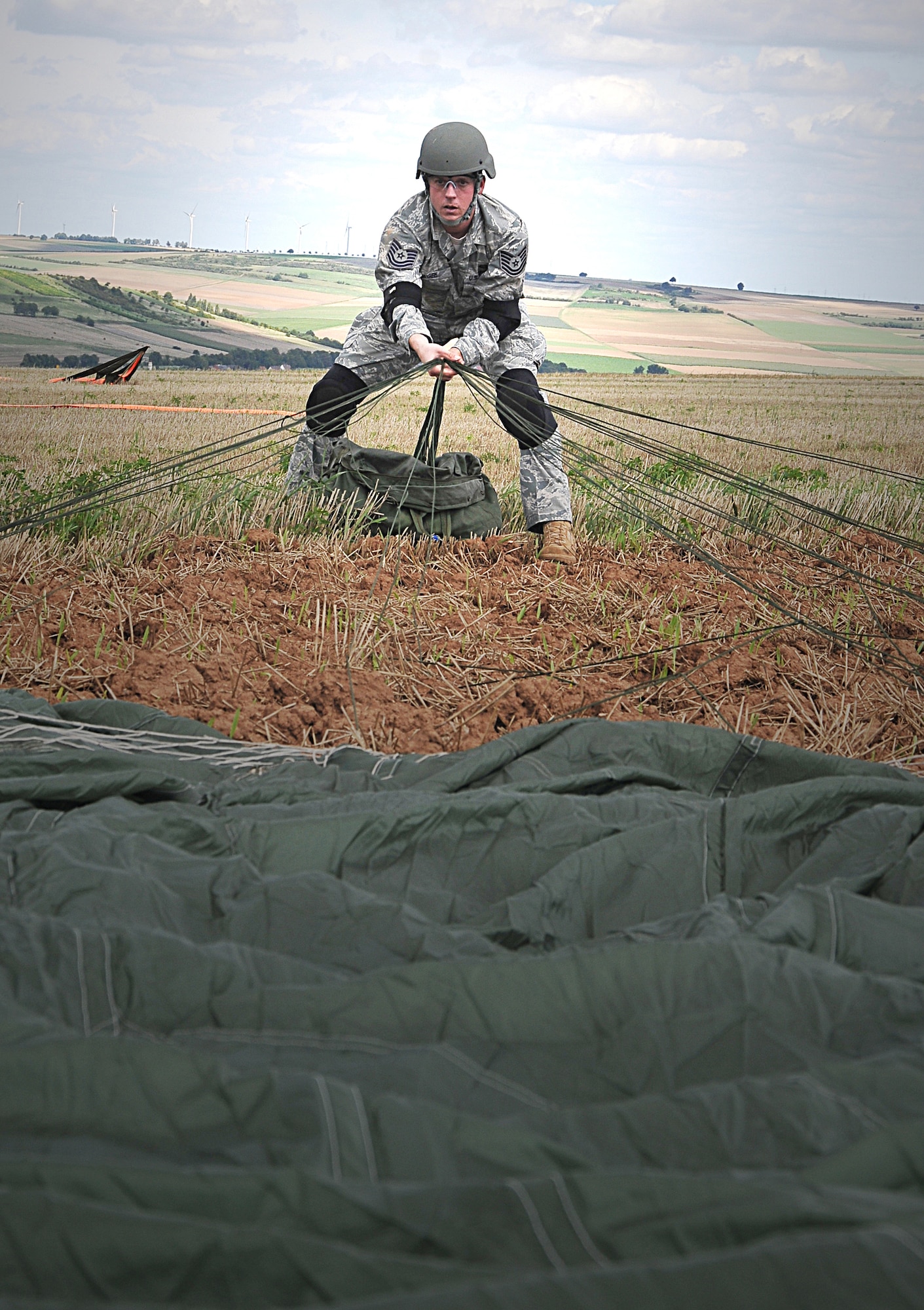Tech. Sgt Shane McGee, a radio frequency transmission systems specialists from Anderson Air Force Base, Guam, pulls his parachute in to pack it away after making a static-line jump from 12,500 feet in the air. More than 200 U.S. and NATO service memebers participated in the week-long training. (U.S. Air Force photo by Staff Sgt. Travis Edwards)

