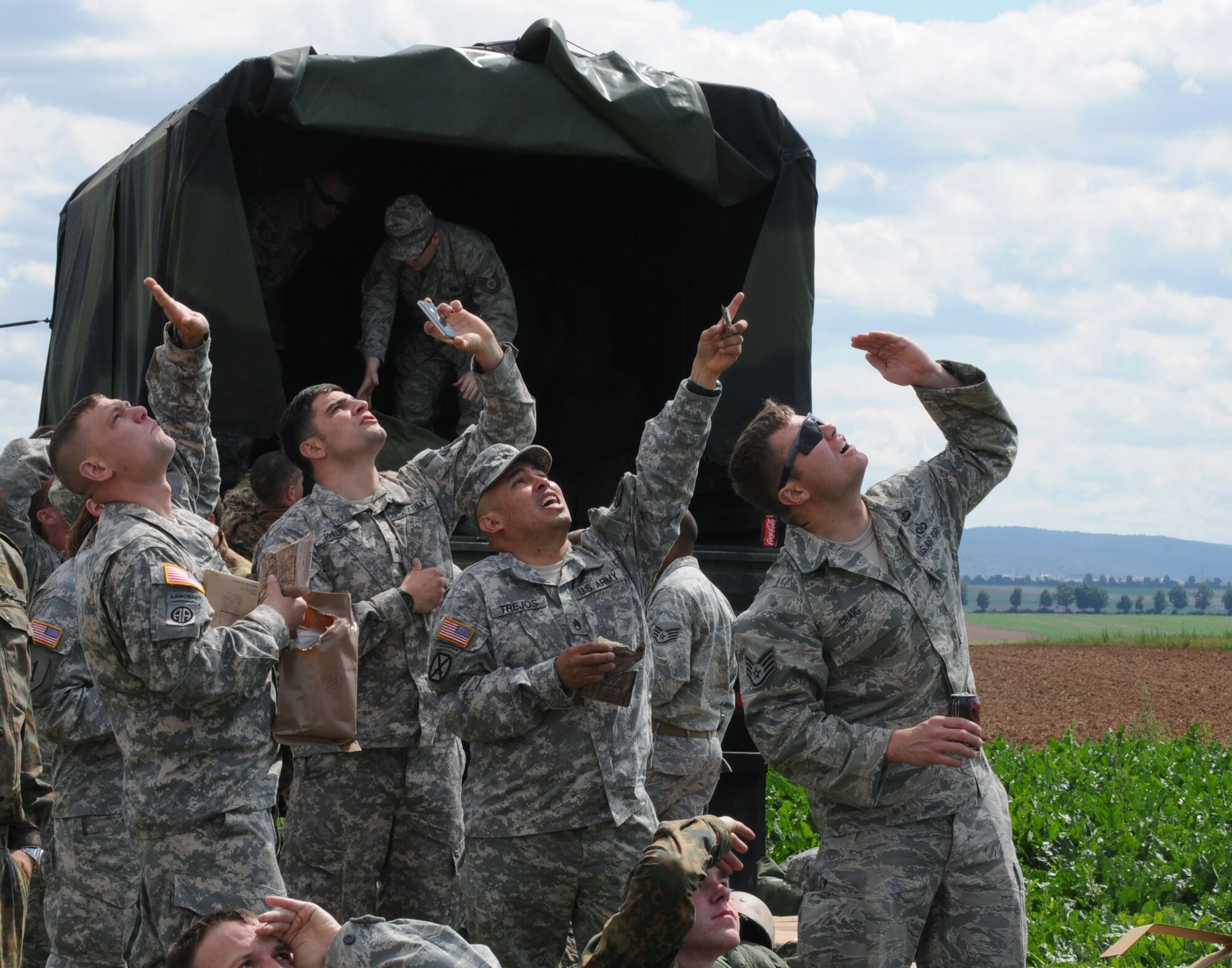 U.S. military members along with service memebers from five other NATO nations watch their comrades parachute over a drop zone during International Jump Week in Marnheim, Germany, Aug. 10, 2011. Six NATO countries participated in the annual event to support one of U.S. Air Forces in Europe's top priorities; building partnership capacity. More than 200 U.S. and NATO service members participated in the week-long training. (U.S. Air Force photo by Airman 1st Class Kendra Alba)