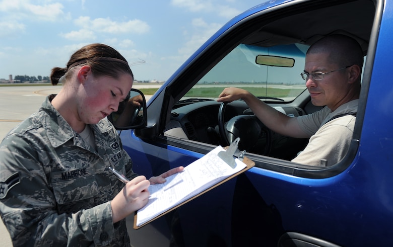 Airman 1st Class Audra Marrone, 39th Operations Squadron airfield management operations coordinator, performs a competency card check with Tech. Sgt. Aaron Gagnon, 39th Logistics Readiness Squadron fixed facility NCO in charge, Aug. 10, 2011, at Incirlik Air Base, Turkey. Airfield management conducts competency card checks to ensure all vehicle operators are qualified to drive on the flightline. (U.S. Air Force photo by Senior Airman Anthony Sanchelli/Released)