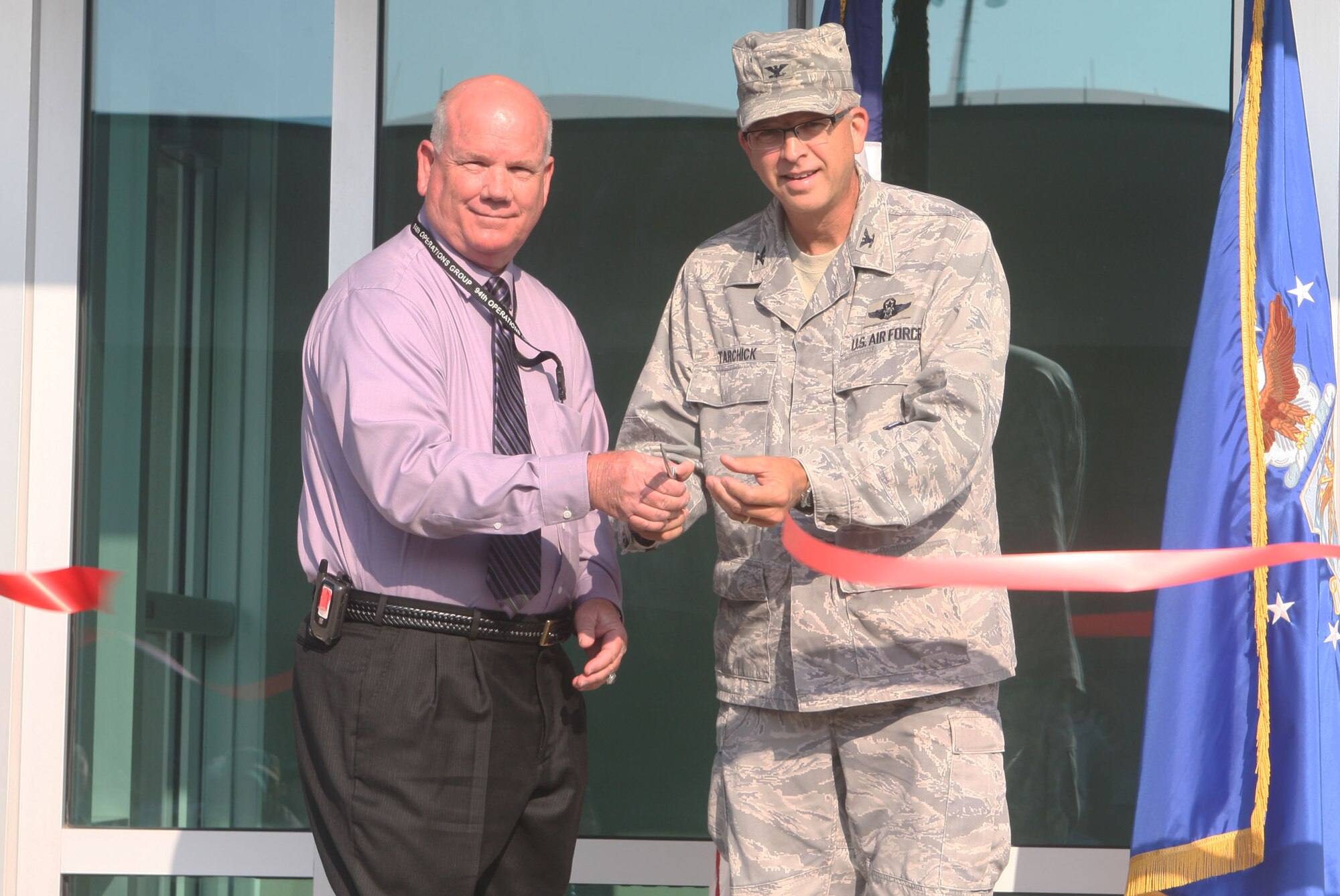 Col. Tim Tarchick joins Clarence Miller, airfield operations manager here, in officially presenting Dobbin’s new air traffic control tower to service members, distinguished guests and visitors Aug. 9. (U.S. Air Force photo/Don Peek)