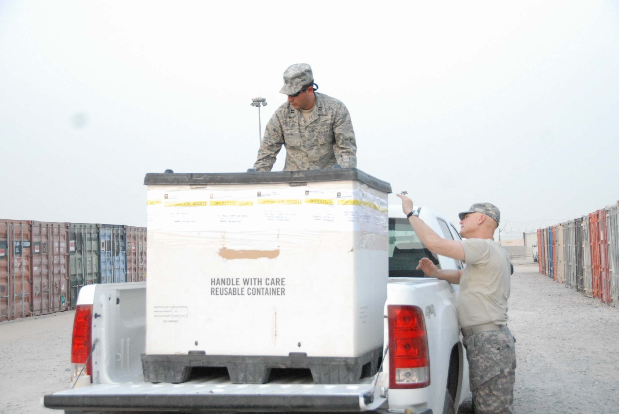 Capt Christian Castro, 386th ELRS and Army Ch (Col) Ronald Huffman seals a container of blankets bound for local Iraqi and Afghani villagers in support of Operation “Woobie” (U.S. Air Force photo by Capt Greta Lewis)
