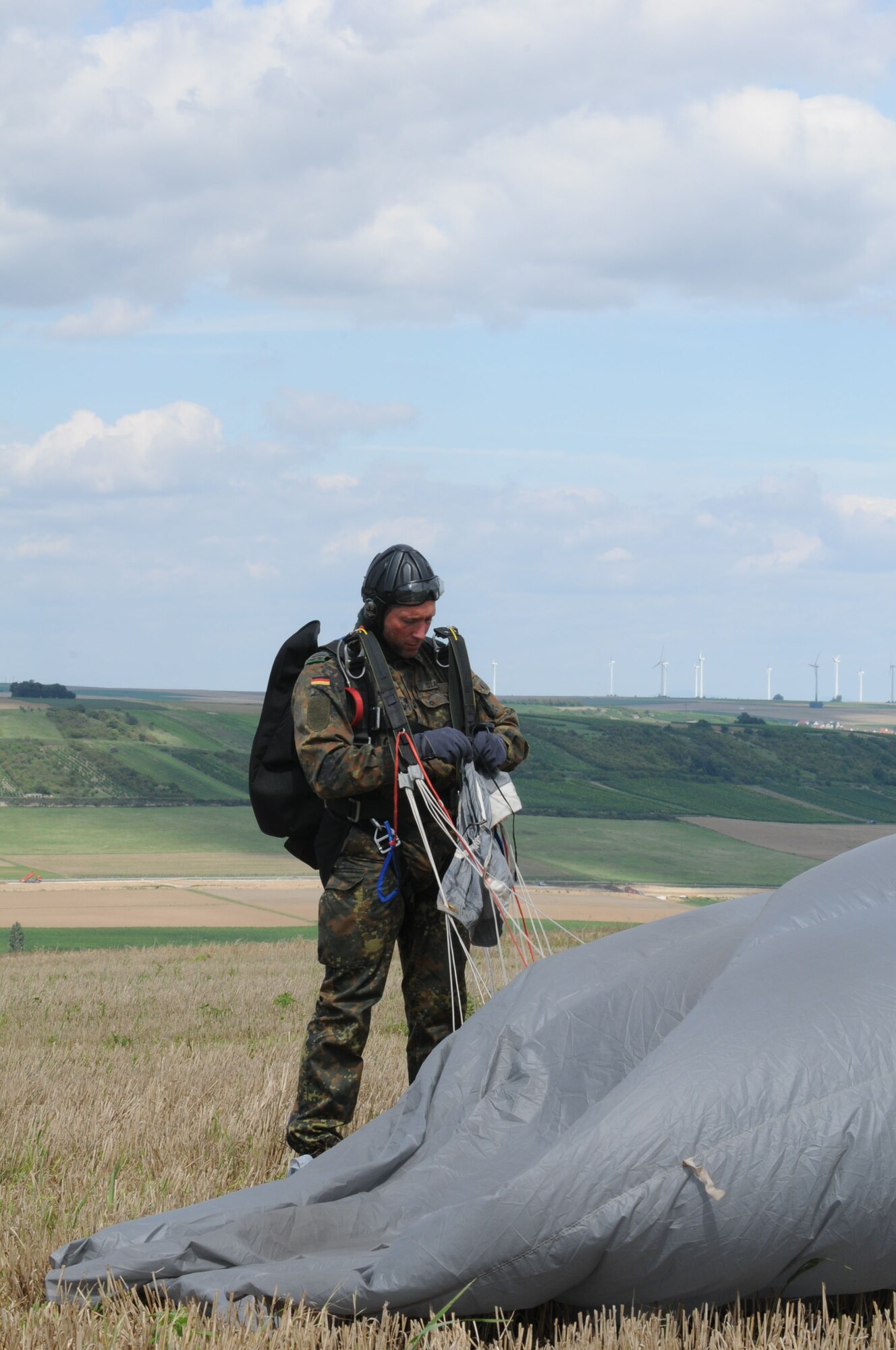 German army Master Sgt. Falko Stadler, Airborne Unit 313, Seedorf, Germany, recovers his gear after a free-fall jump during International Jump Week in Marnheim, Germany, Aug. 10, 2011. Six NATO countries participated in the annual event to support one of U.S. Air Forces in Europe's top priorities; building partnership capacity. More than 200 U.S. and NATO jumpers participated in the week-long training. (U.S. Air Force photo by Airman 1st Class Kendra Alba)