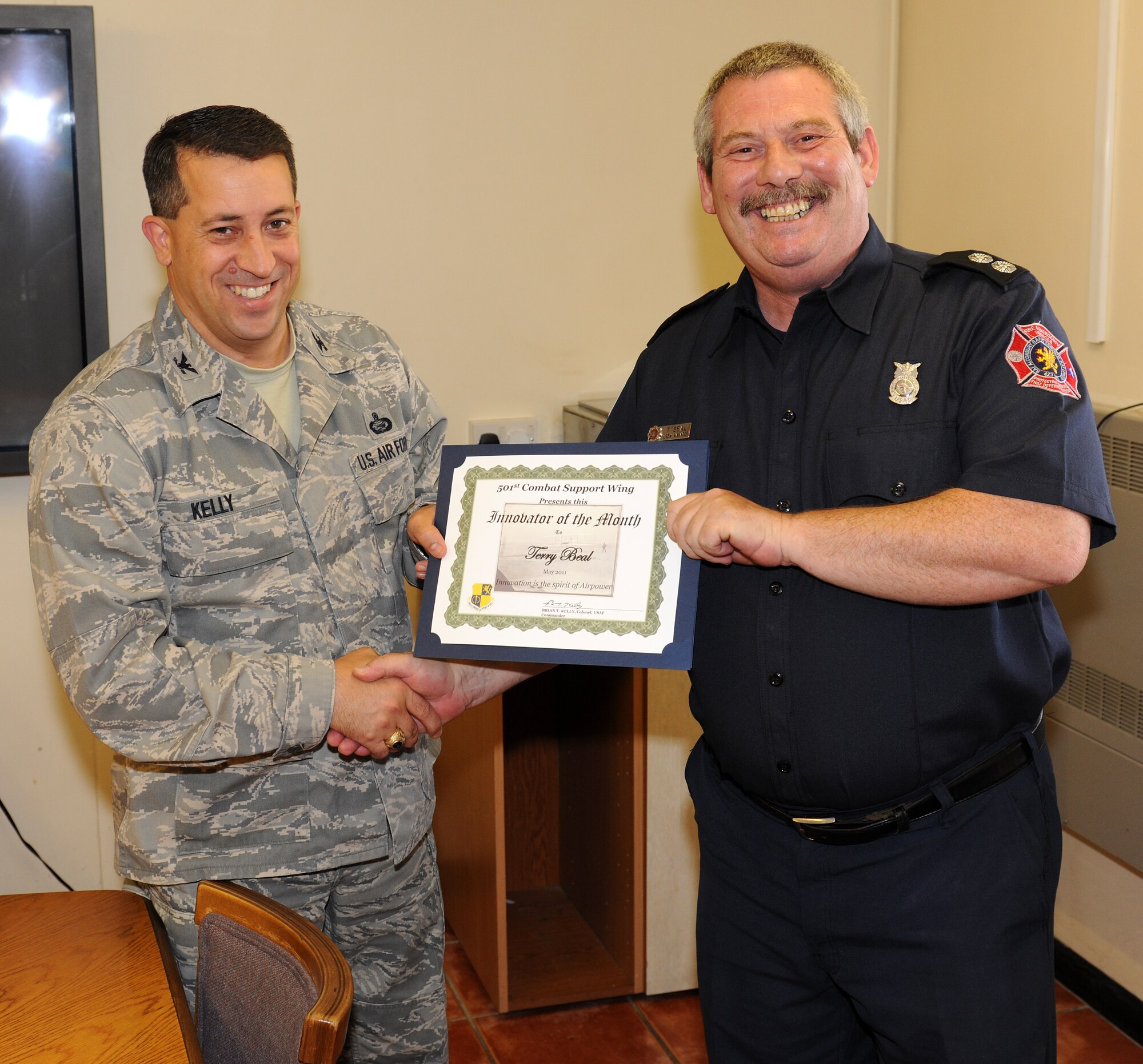 RAF ALCONBURY, United Kingdom - Col. Brian Kelly, 501st Combat Support Wing commander, presents the Innovator of the Month award to Terry Beal, 423 Civil Engineer Squadron Fire Department. Beal's innovation allows the fire department to conduct local rescue training, which normally would be performed by an American Red Cross instructor saving the wing $1,600 this year and $400 every third year. (U.S. Air Force photo by 1st Lt. Brian Maguire)