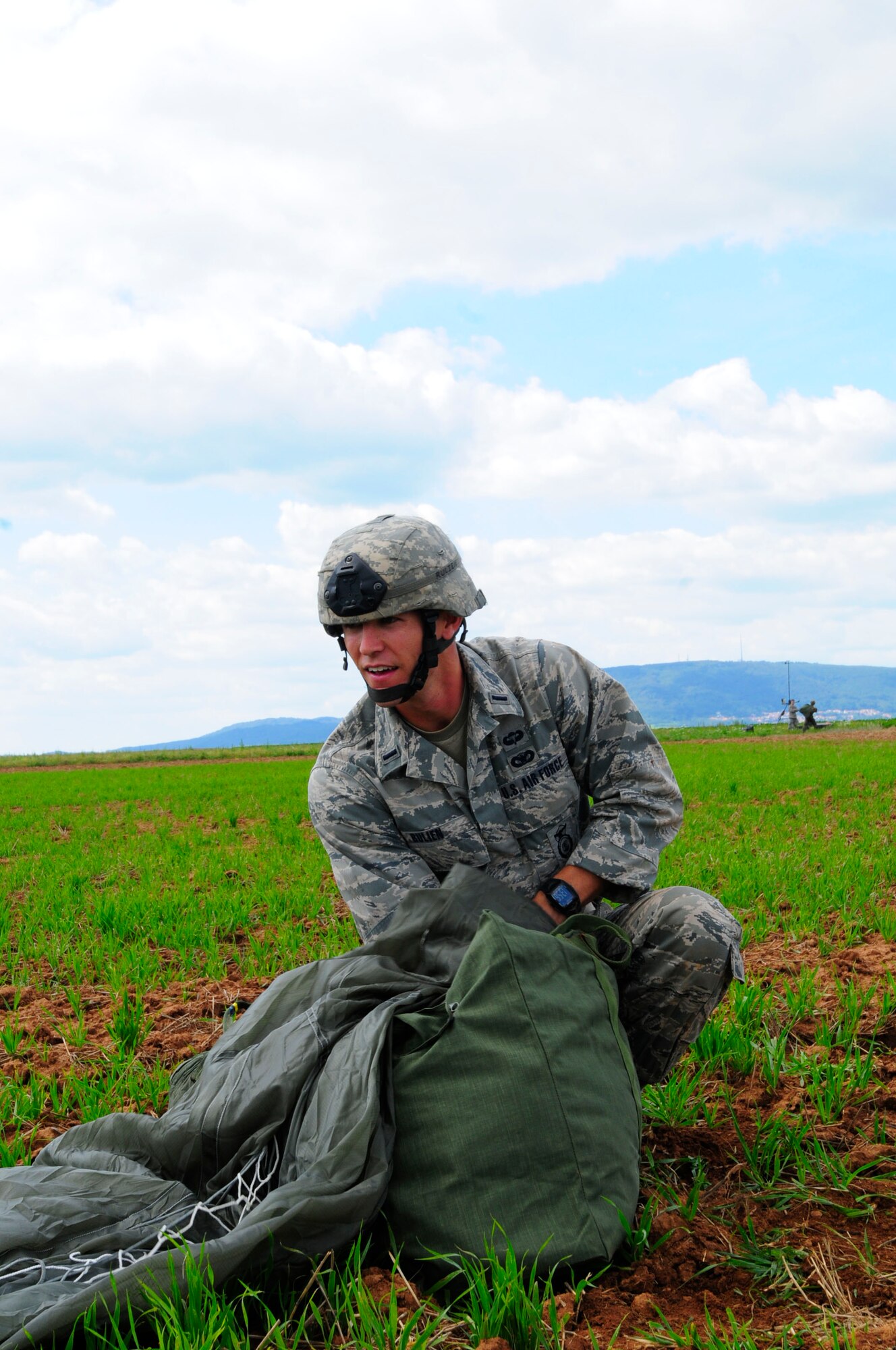 U.S. Air Force 1st Lt. John Rulien, 824th Base Defense Squadron, Moody Air Force Base, Ga., recovers his gear after landing in the designated drop zone during International Jump Week in Marnheim, Germany, Aug. 10, 2011. Six NATO countries participated in the annual event to support one of United States Air Forces in Europe's top priorities; building partnership capacity. More than 200 U.S. and NATO service members participated in the week-long training. (U.S. Air Force photo by Airman 1st Class Kendra Alba)