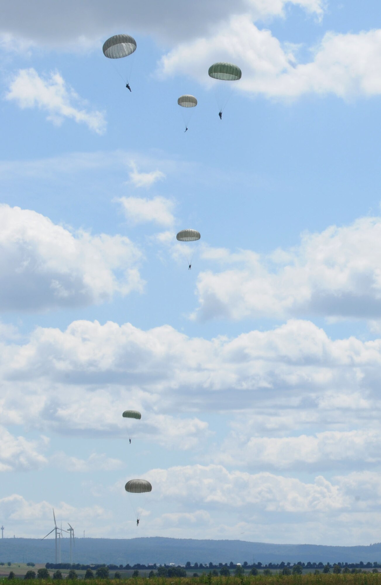 U.S. military members along with soldiers from six NATO nations parachute off a C-130 Hercules over a drop zone during International Jump Week in Marnheim, Germany, Aug. 10, 2011. Six NATO countries participated in the annual event to support one of United States Air Forces in Europe's top priorities; building partnership capacity. More than 200 U.S. and NATO service members participated in the week-long training. (U.S. Air Force photo by Airman 1st Class Kendra Alba)