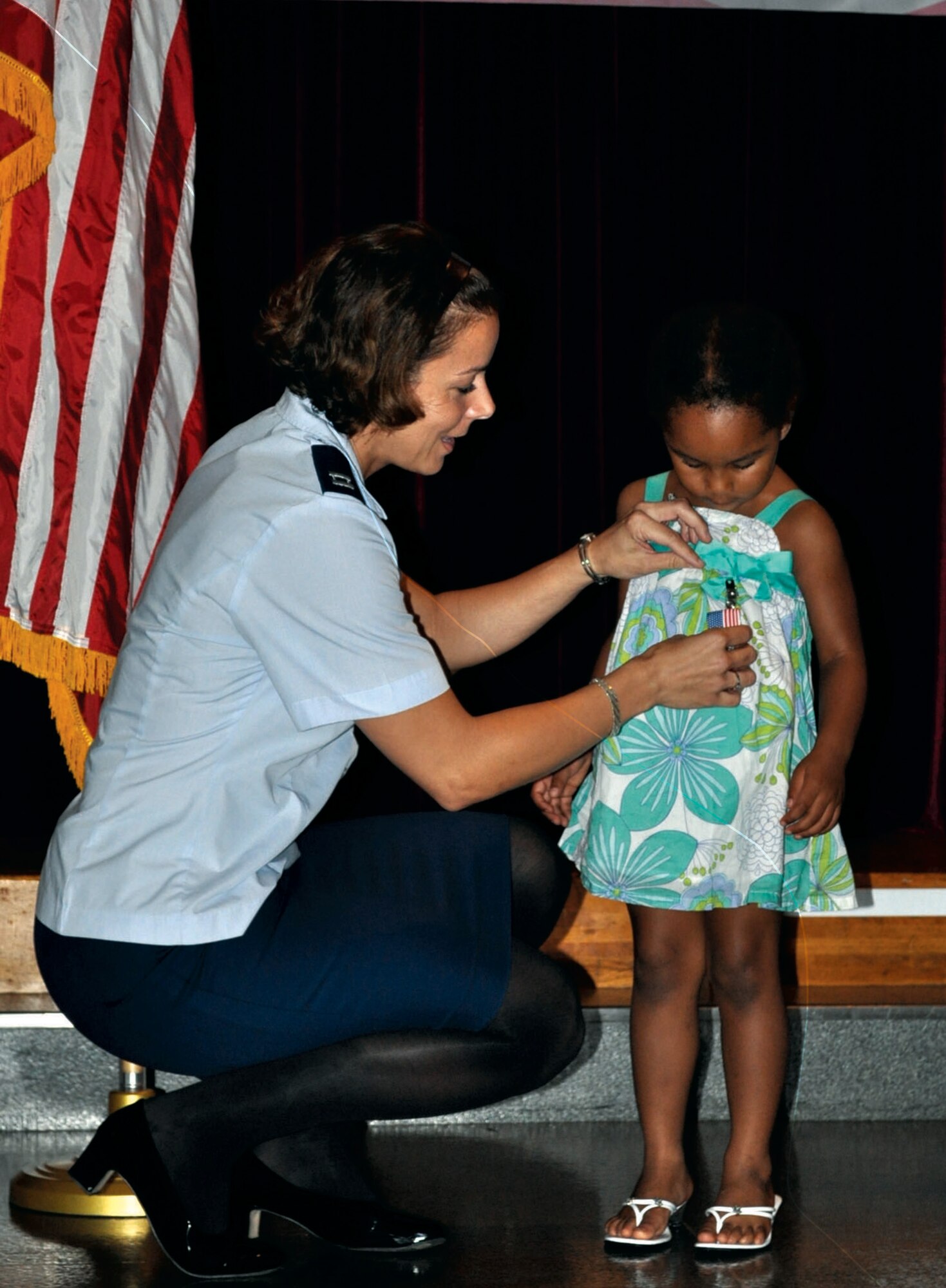 YOKOTA AIR BASE, Japan -- Capt. Karina Glover, 374th Surgical Operations Squadron general surgery physician assistant, pins a medal on her 4-year-old daughter, Isabella, at the Homefront Heroes ceremony held Aug. 8, 2011, at the Airman and Family Readiness Center at Yokota Air Base, Japan. Isabella and 11 other children were honored by their parents during the ceremony. The Homefront Heroes program recognizes the contributions of military children while one or more parent is deployed. (U.S. Air Force photo/Airman 1st Class Desiree Economides)