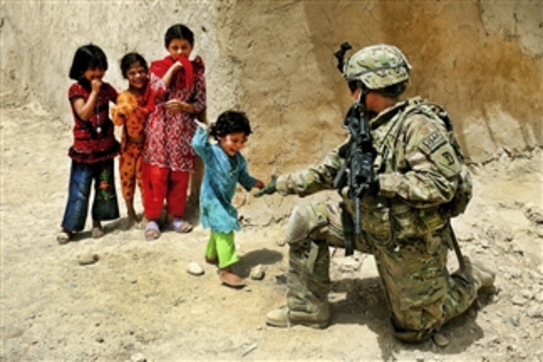 U.S. Air Force Senior Airman Sarah Baker greets children during a security halt in Qalat City, Afghanistan, on Aug. 10, 2011.  Baker is assigned to the Provincial Reconstruction Team Zabul's security force.  
