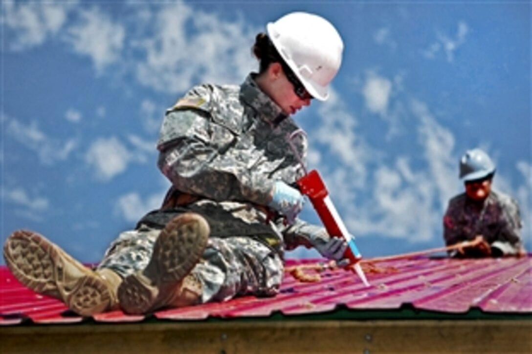 U.S. Army Pfc. Danielle Robinson seals gaps in a metal roof during the engineering program portion of Khaan Quest 2011, a training exercise in Ulaanbaatar, Mongolia, Aug. 6, 2011. Robinson is a carpenter and mason assigned to the 643rd Company, 84th Battalion, 30th Brigade. The program is intended to improve medical care in the area by adding on to the Ayut Family Hospital, an urgent care clinic.