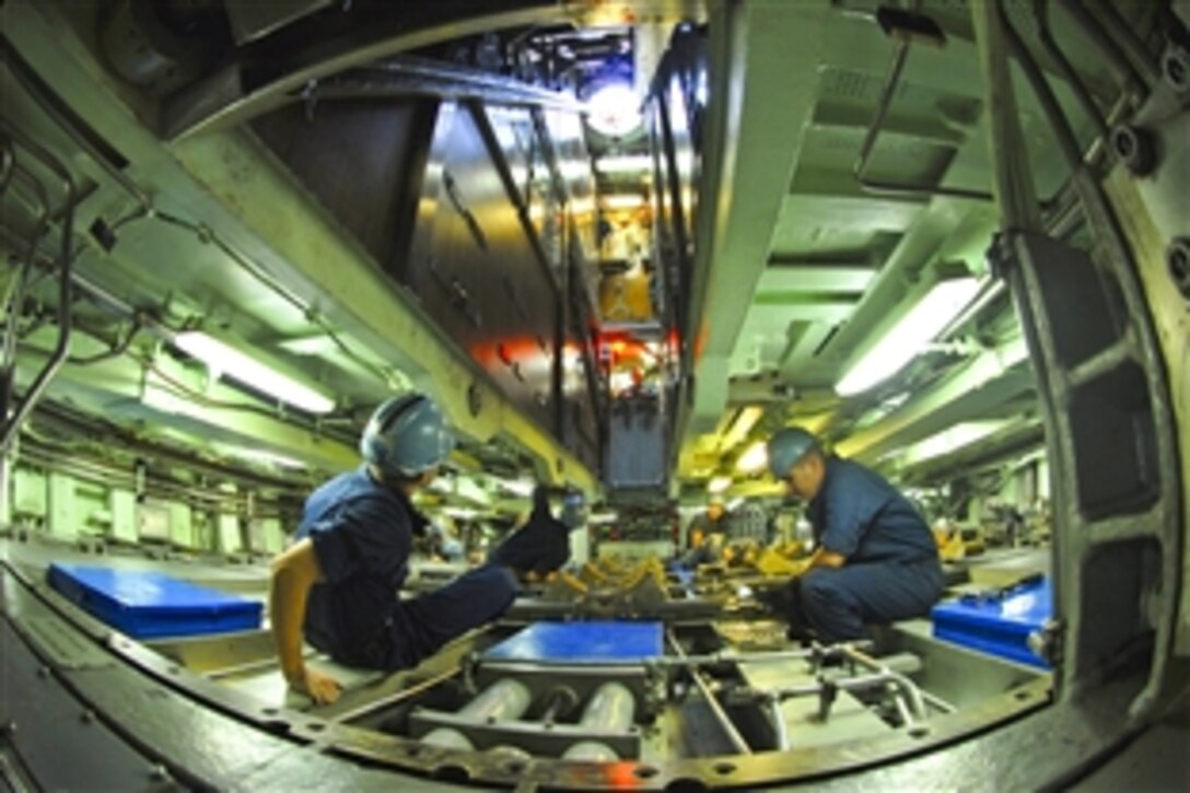 The weapons team in the torpedo room aboard the attack submarine USS Albany prepares to receive a torpedo in Norfolk, Va., Aug. 10, 2011. The Albany recently completed four months of maintenance at Newport News Shipyard.