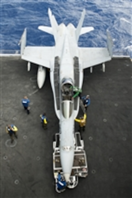 U.S. Navy sailors prepare to maneuver an F/A-18C Hornet aircraft, assigned to Strike Fighter Squadron 97, on the aircraft carrier USS John C. Stennis (CVN 74) in the Pacific Ocean on Aug. 9, 2011.  The John C. Stennis Carrier Strike Group is on a western Pacific Ocean and Arabian Gulf deployment.  