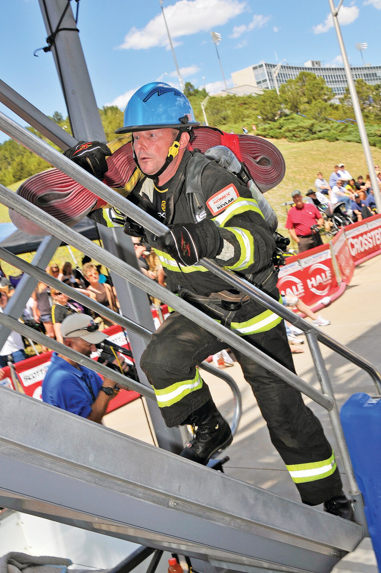 Air Force Academy Firefighter Dan Mcauliffe competes in the stair climb event during the Firefighter Challenge competition at the Academy Aug. 6. Competitors must carry a 42-pound hose up six flights of stairs while wearing a  a helmet, coat, pants with liners, boots, gloves and a breathing apparatus. (U.S. Air Force Photo/Raymond McCoy