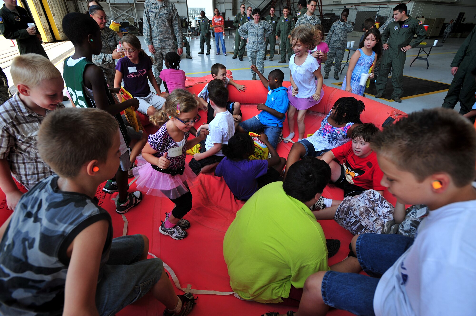 Children jump in the inflatable life raft during the “Big for a Day” event Aug. 12, 2011, at McConnell Air Force Base, Kan.  Team McConnell hosted approximately 40 children from the Sedgwick County chapter of the Big Brothers Big Sisters organization.  (U.S. Air Force photo/ Senior Airman Courtney Witt)