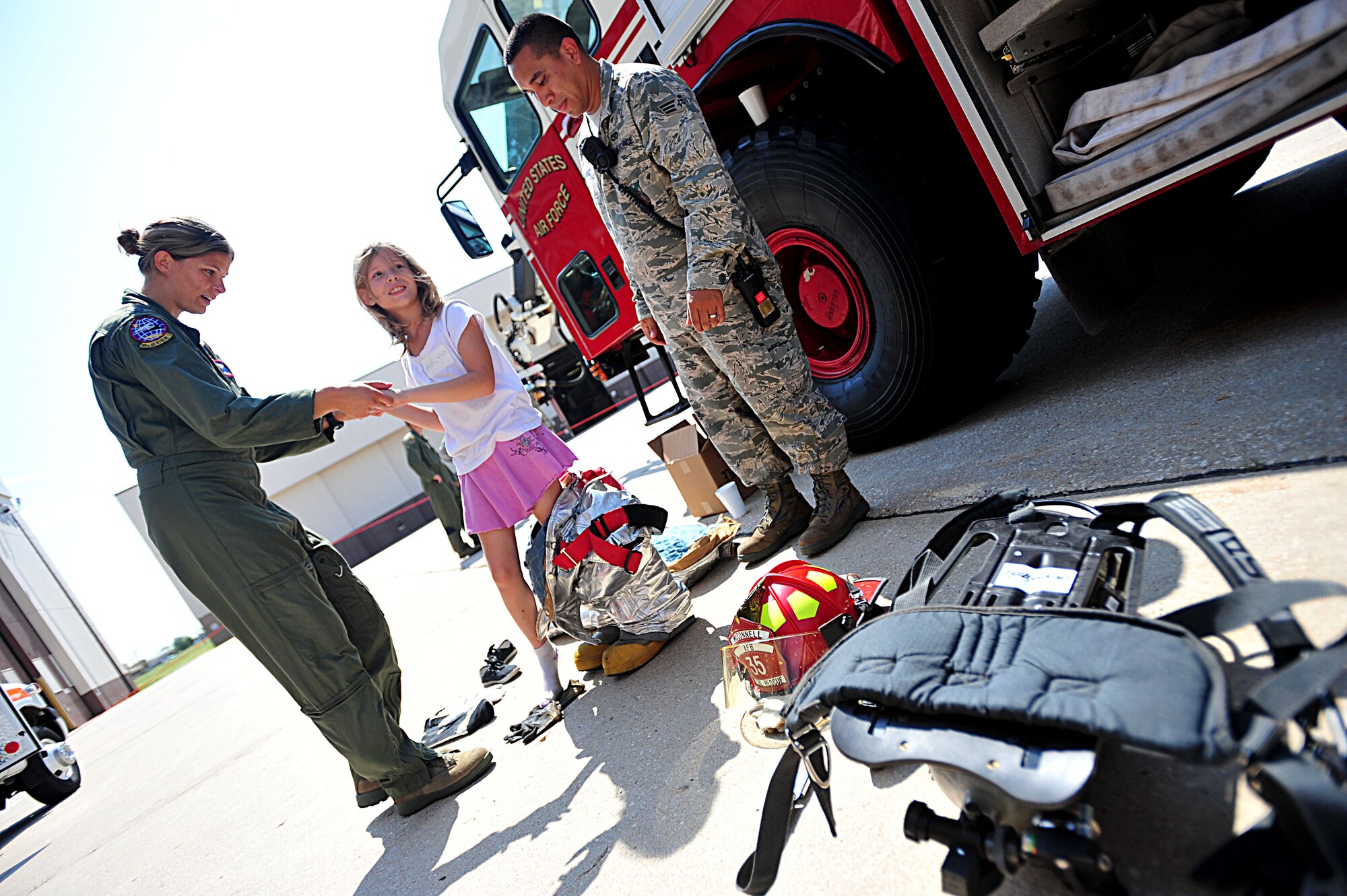 Capt. Nicole Westmoreland, 349th Air Refueling Squadron flight commander, helps Ashlynn, 9, out of a fire suit during the “Big for a Day” Aug. 12, 2011, at McConnell Air Force Base, Kan. Children from the Sedgwick County chapter of Big Brothers Big Sisters visited McConnell to experience the mission of the 22nd Air Refueling Wing. (U.S. Air Force photo/ Senior Airman Courtney Witt)

