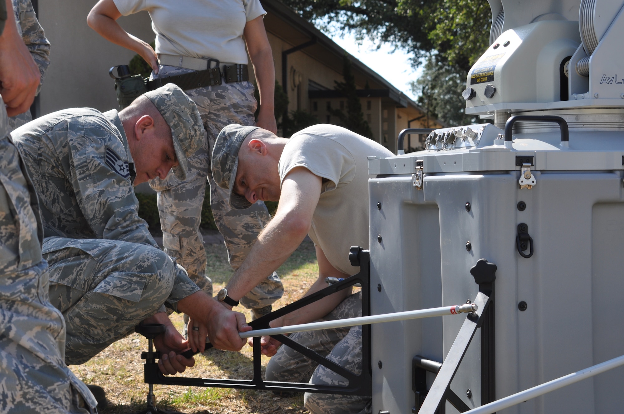 Master Sergeant Daryl Lamb and Staff Sergeant Robert Catts from 301st Comm Flight install a cross beam to structurally support the Joint Incident Site Communications Capability being assembled for a training exercise at Naval Air Station Fort Worth Jont Reserve Base August 9, 2011. (U.S. Air Force photo by Senor Airmen Jacob Jimenez/482d Fighter Wing Public Affairs)