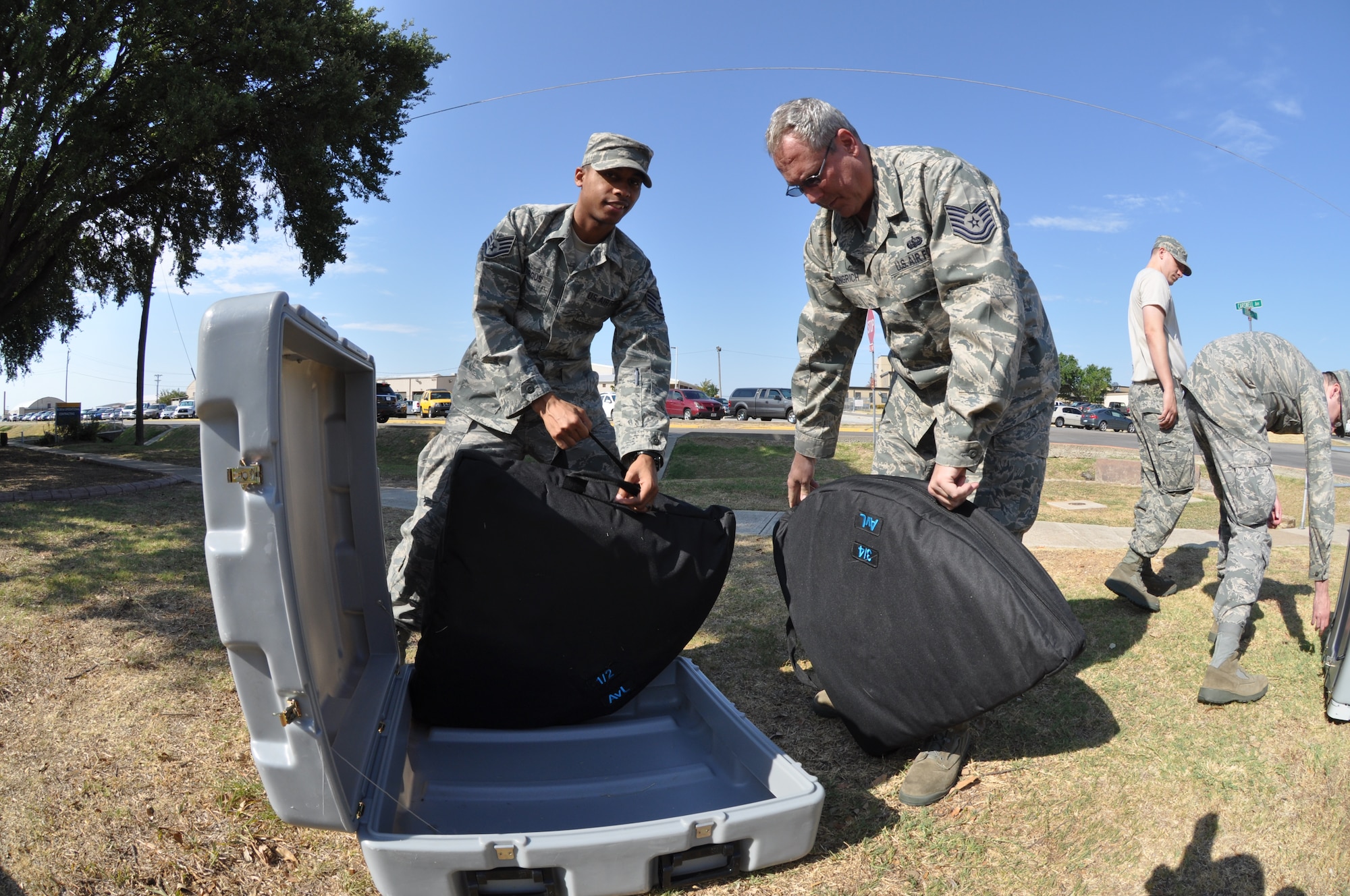 Staff Sergeant Stirgus and Tech Sergeant Gingrich from the 301st Comm Flight, carefully unpack a Satellite Dish to the Joint Incident Site Communications Capability being assembled for a training exercise at Naval Air Station Fort Worth Jont Reserve Base August 9, 2011. (U.S. Air Force photo by Senor Airmen Jacob Jimenez/482d Fighter Wing Public Affairs)