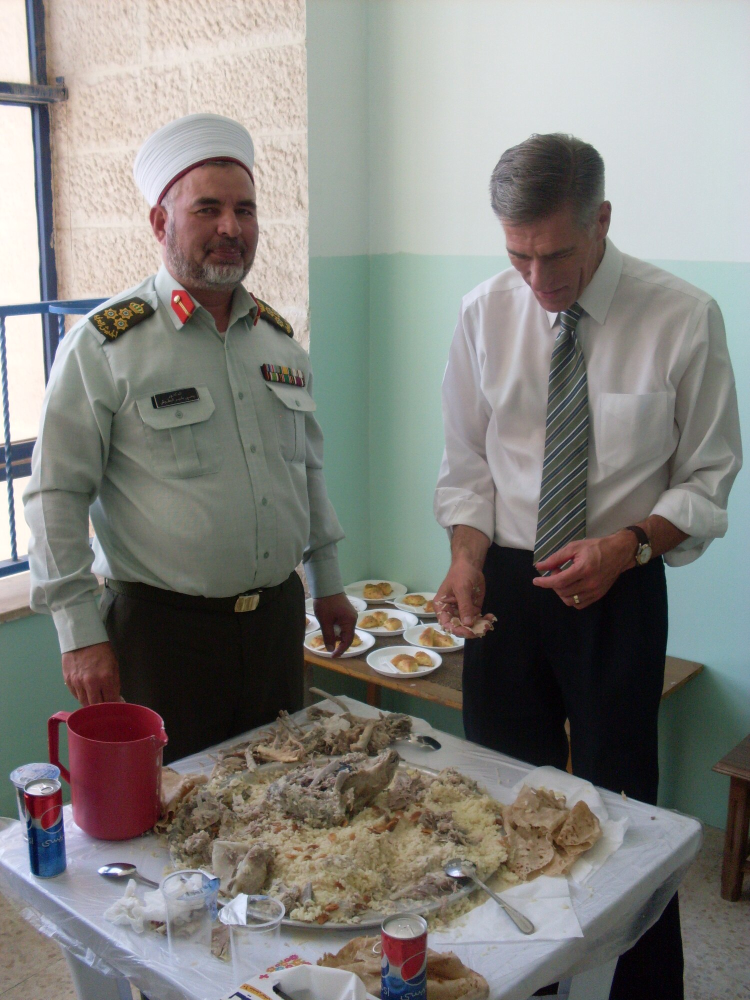 On the last day of the visit, the group enjoyed a traditional meal composed of four huge round trays covered with rice and slivered almonds; each tray was a sizeable cooked goat. Mufti (their senior chaplain) and Chaplain Prosise enjoyed the Mansef together. (Photo courtesy of Army Col. Andy Meverden, Colorado National Guard Chaplain)